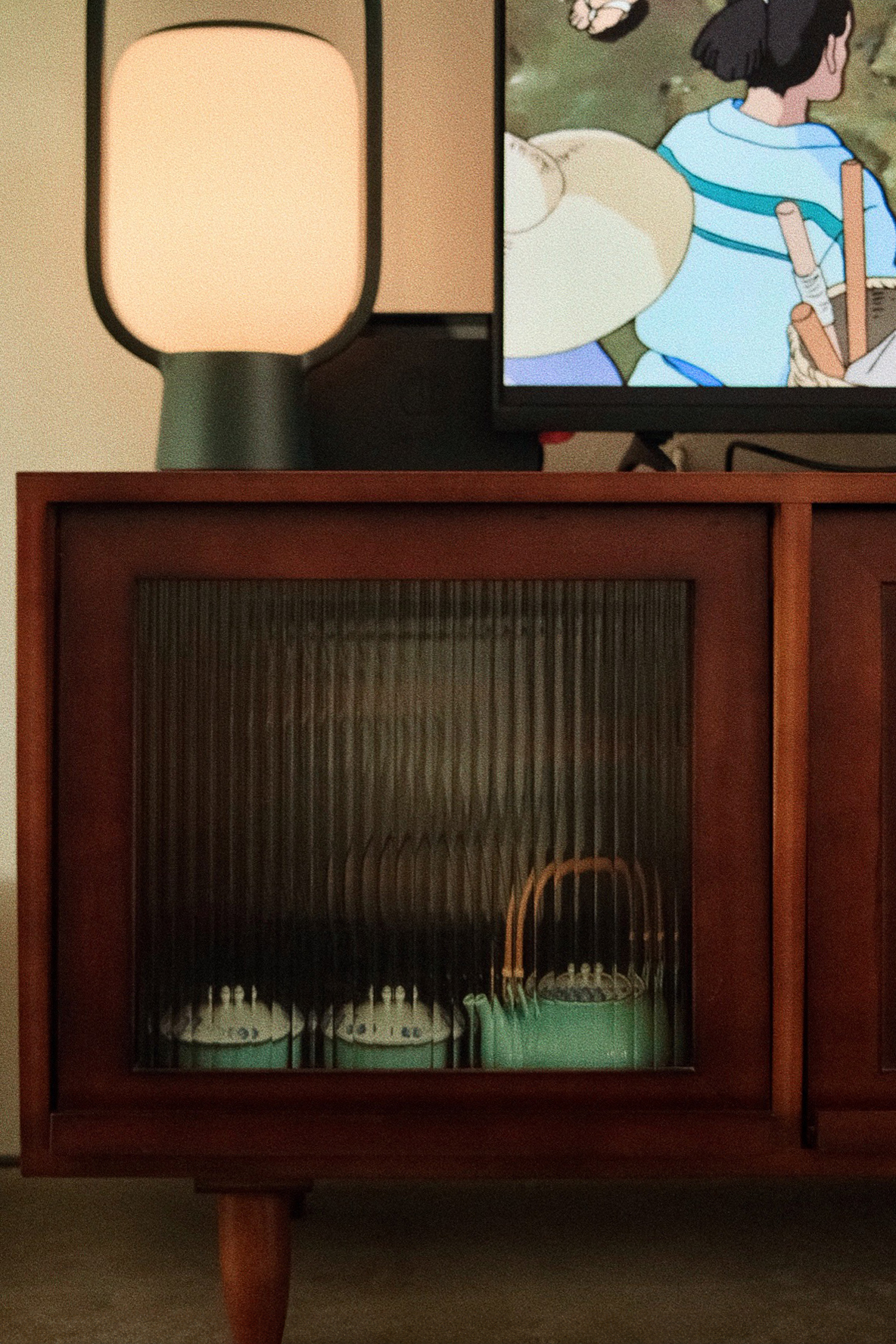 Open living room concept for a heritage style artsy home - Lamp with a soft, warm glow, wooden cabinet with glass doors