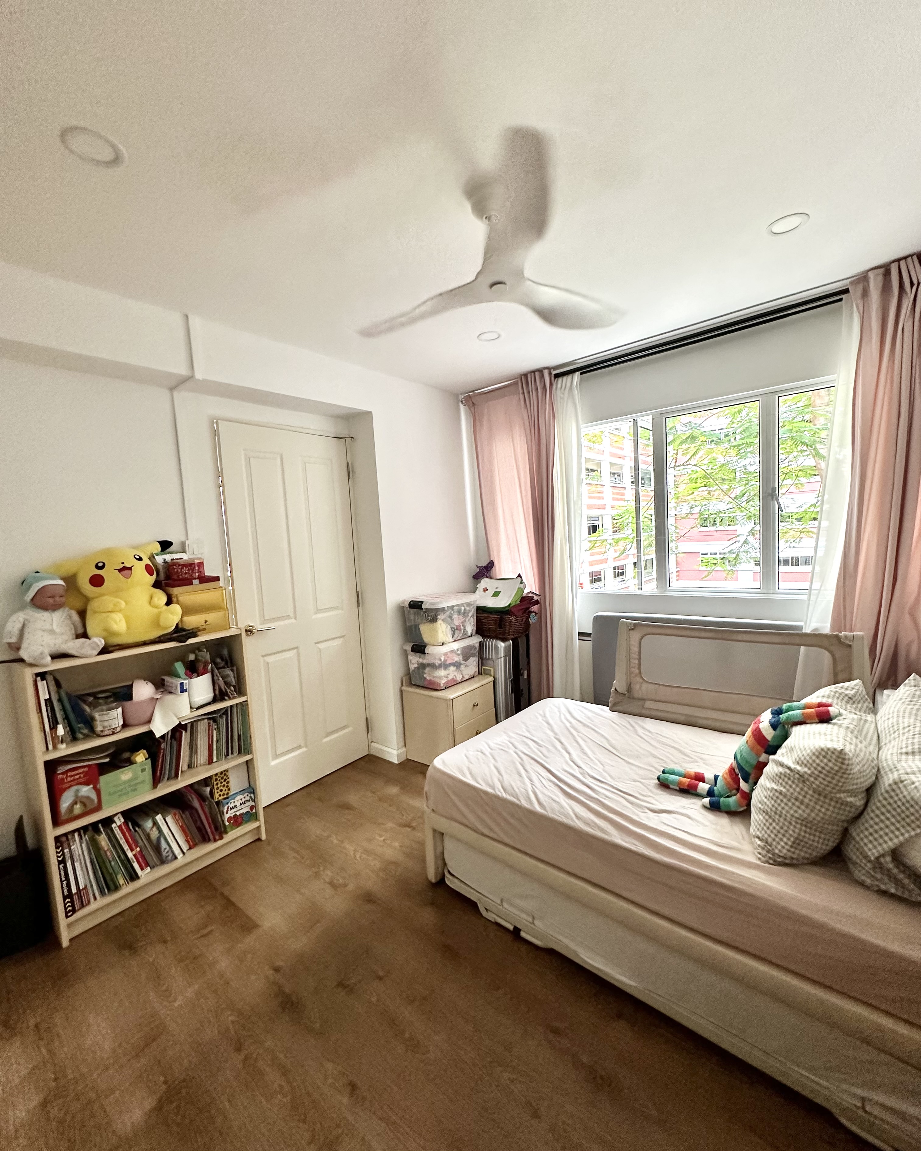 Kid’s Bedroom Makeover!  - Bookshelf, Pikachu plush toy, white door, wooden floor, window with pink curtains, bed with