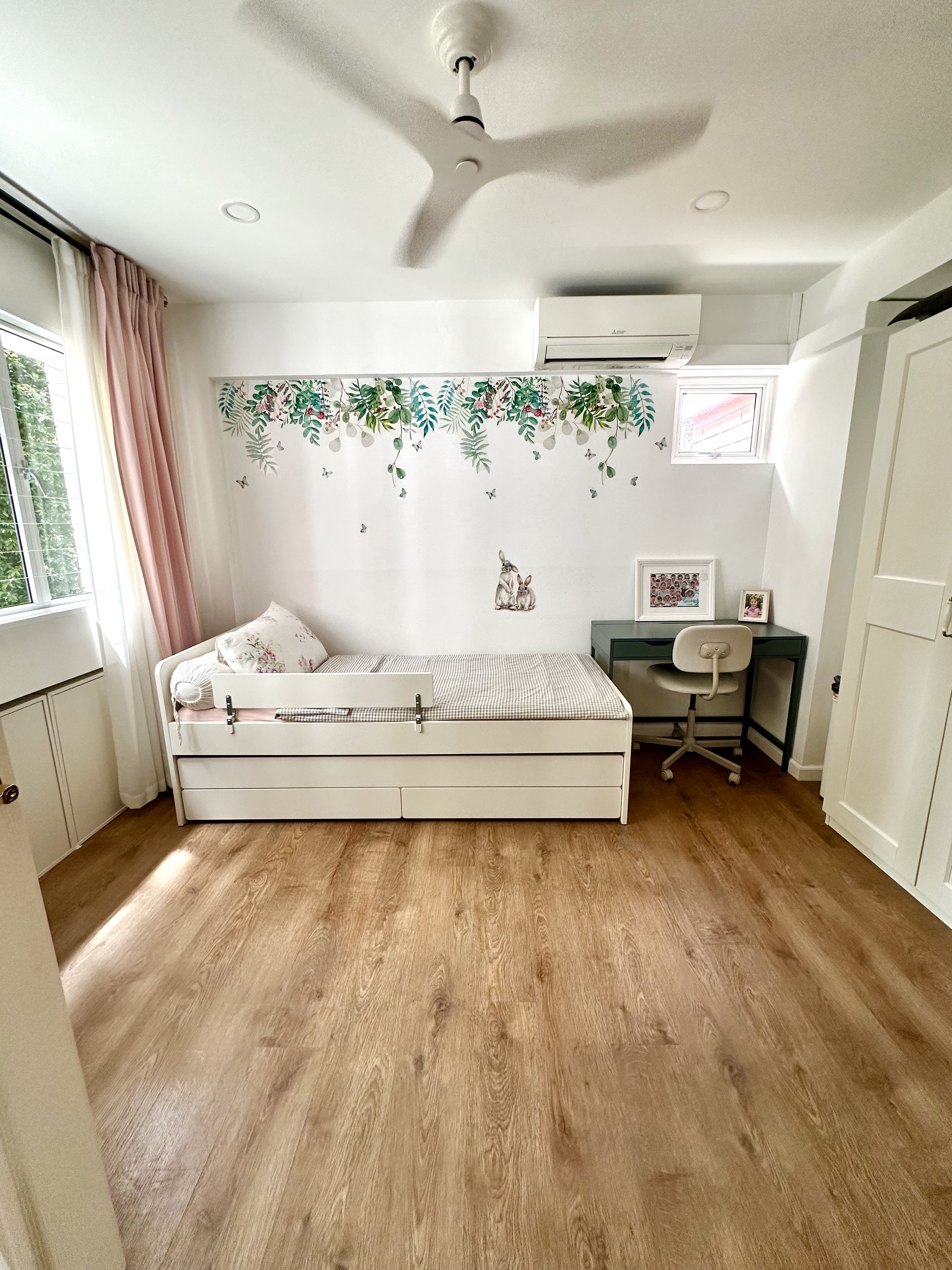 Kid’s Bedroom Makeover!  - White bedroom with wooden floor, ceiling fan, and light-colored walls. Large bed with floral