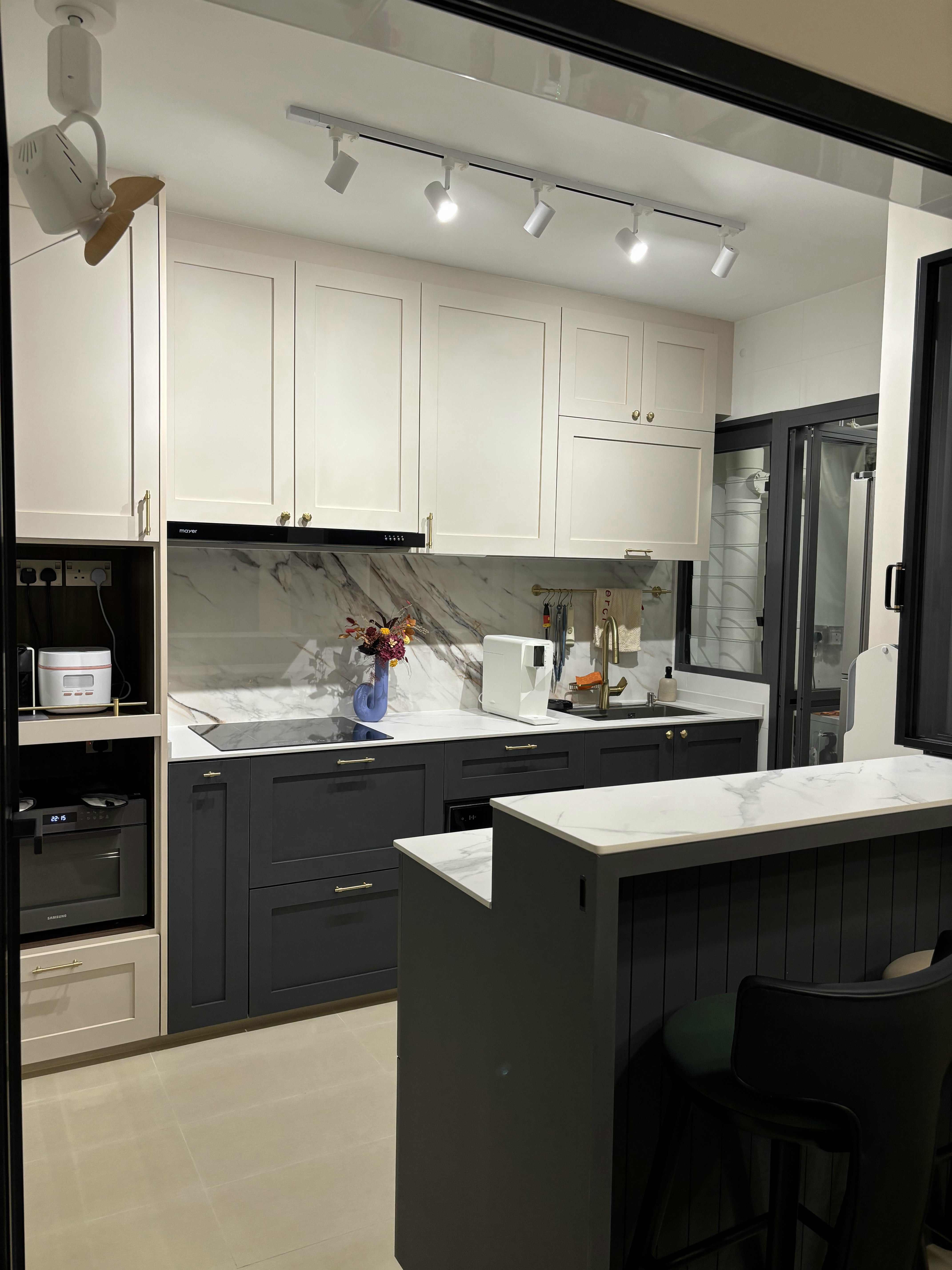 Our Favourite Features in the Kitchen - Modern kitchen with sleek design, white cabinets, marble backsplash, under-cabinet