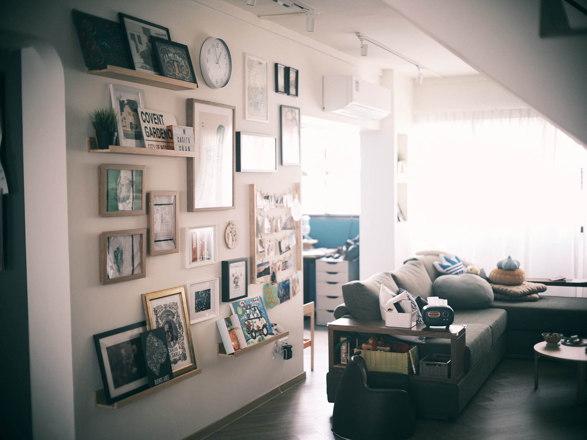 A relaxing mid-century family lounge area - Wall adorned with various framed pictures, artwork, and certificates, cozy living