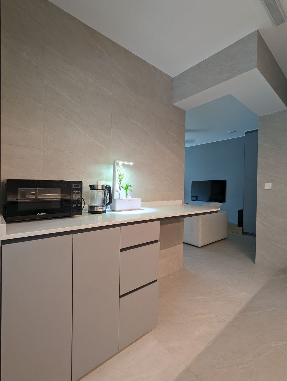 Our minimalistic open concept kitchen! - Modern kitchen with sleek design, beige marble walls, minimalist appliances, black