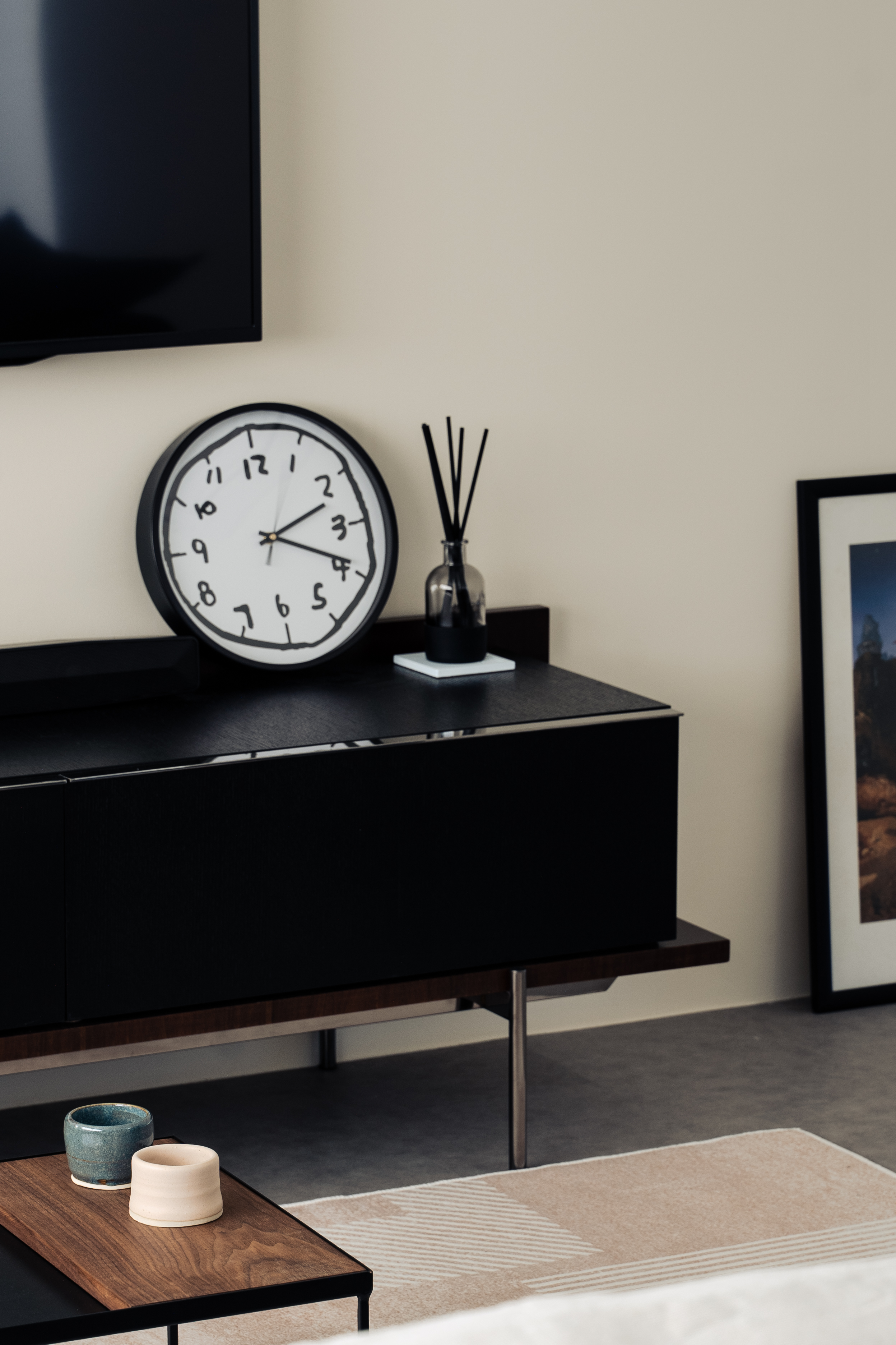 Our Living Area: A space for books, games and quirky clocks - Modern minimalist living room, black TV stand, white clock