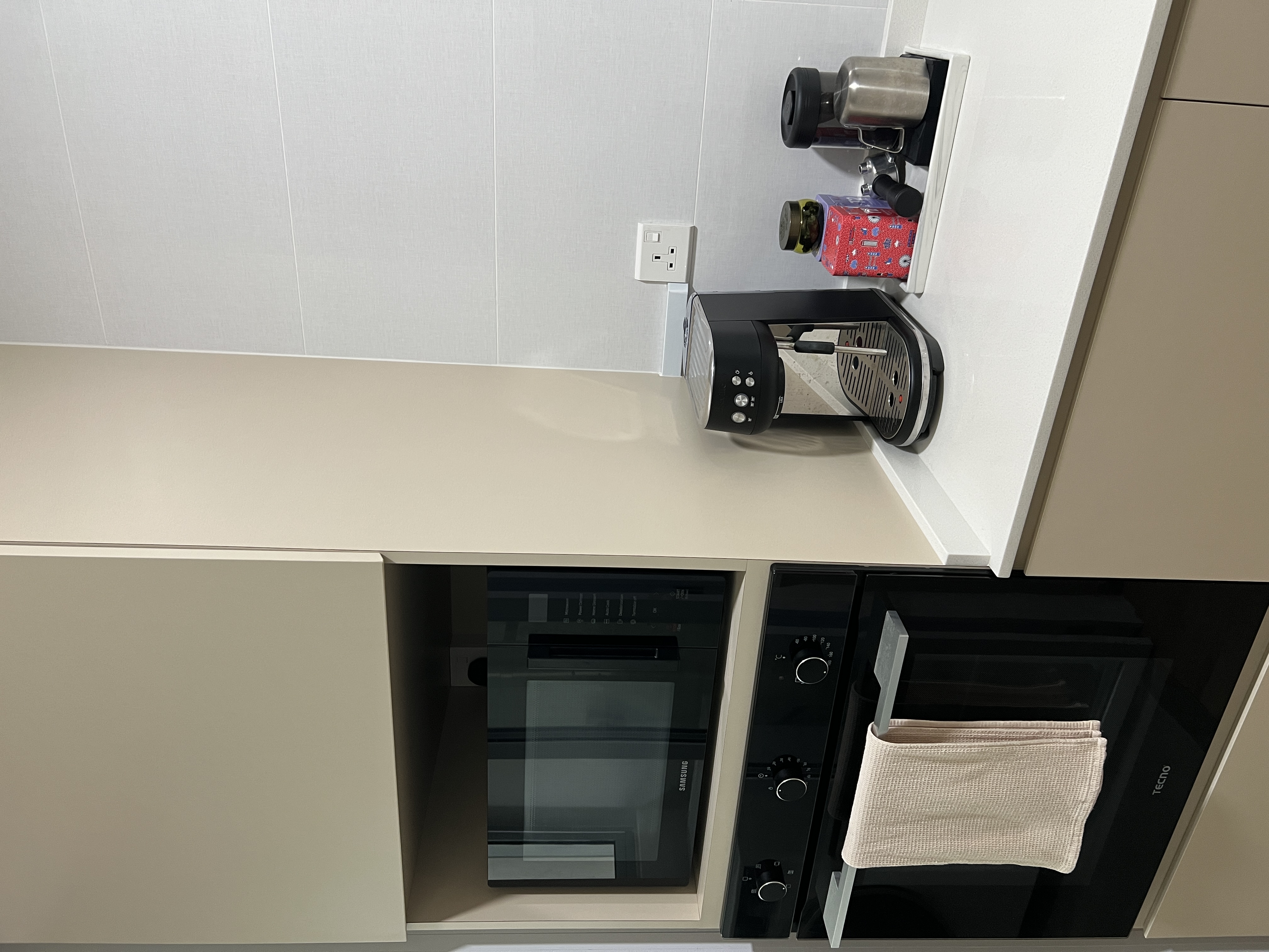 A neutral-minimalist-functional Kitchen - coffee maker, microwave, kitchen counter, modern appliances, white cabinets, beige