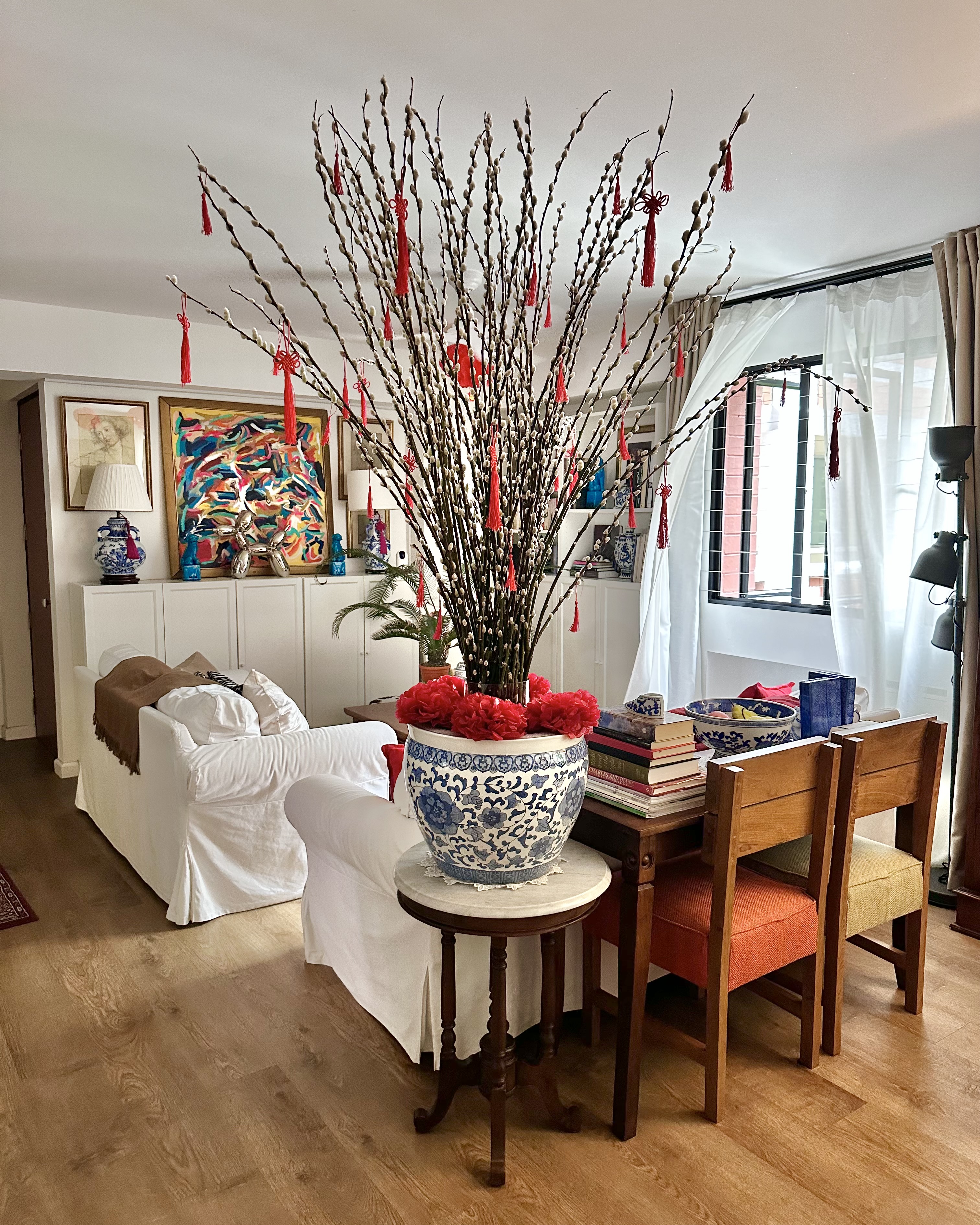 A Festive Home Ready to Welcome the Year of Dragon - Chinese branches with red tassels, white and blue vase, wooden dining