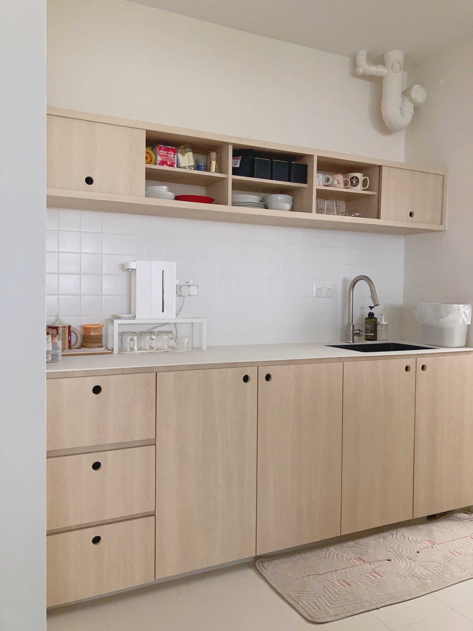 Simple but unconventional open concept kitchen  - Light wood kitchen cabinets, white tiled backsplash, built-in shelves