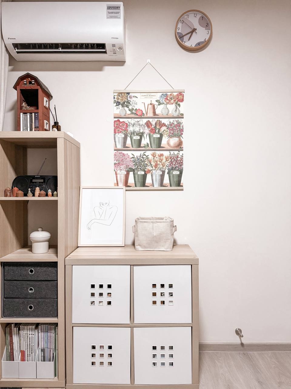 The half-half room - Wooden shelf, decorative clock, vintage radio, framed artwork, white drawers, black storage bins, small