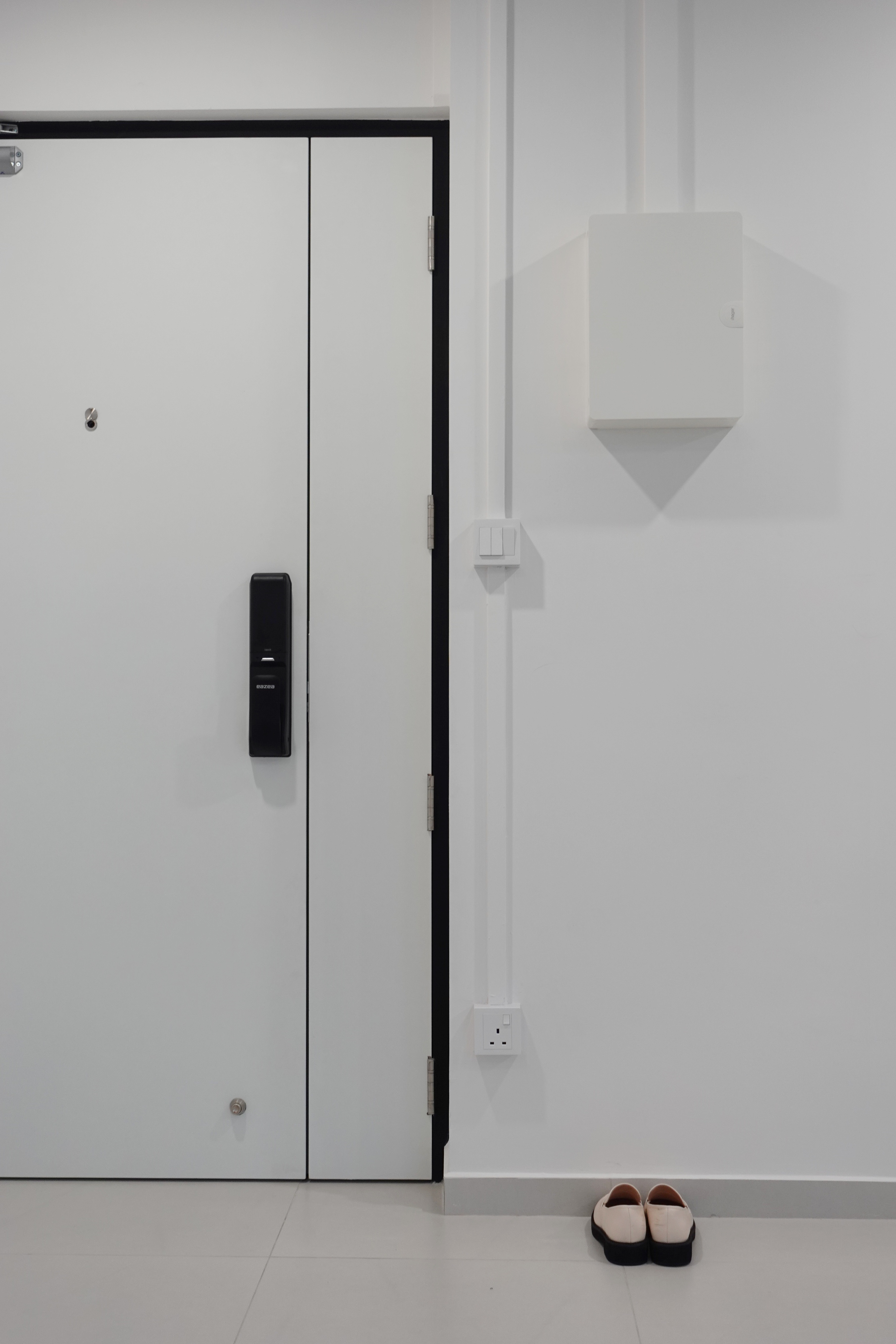 A minimal living room with a full out DIY TV console - White door with black electronic keypad, minimalist design, sleek