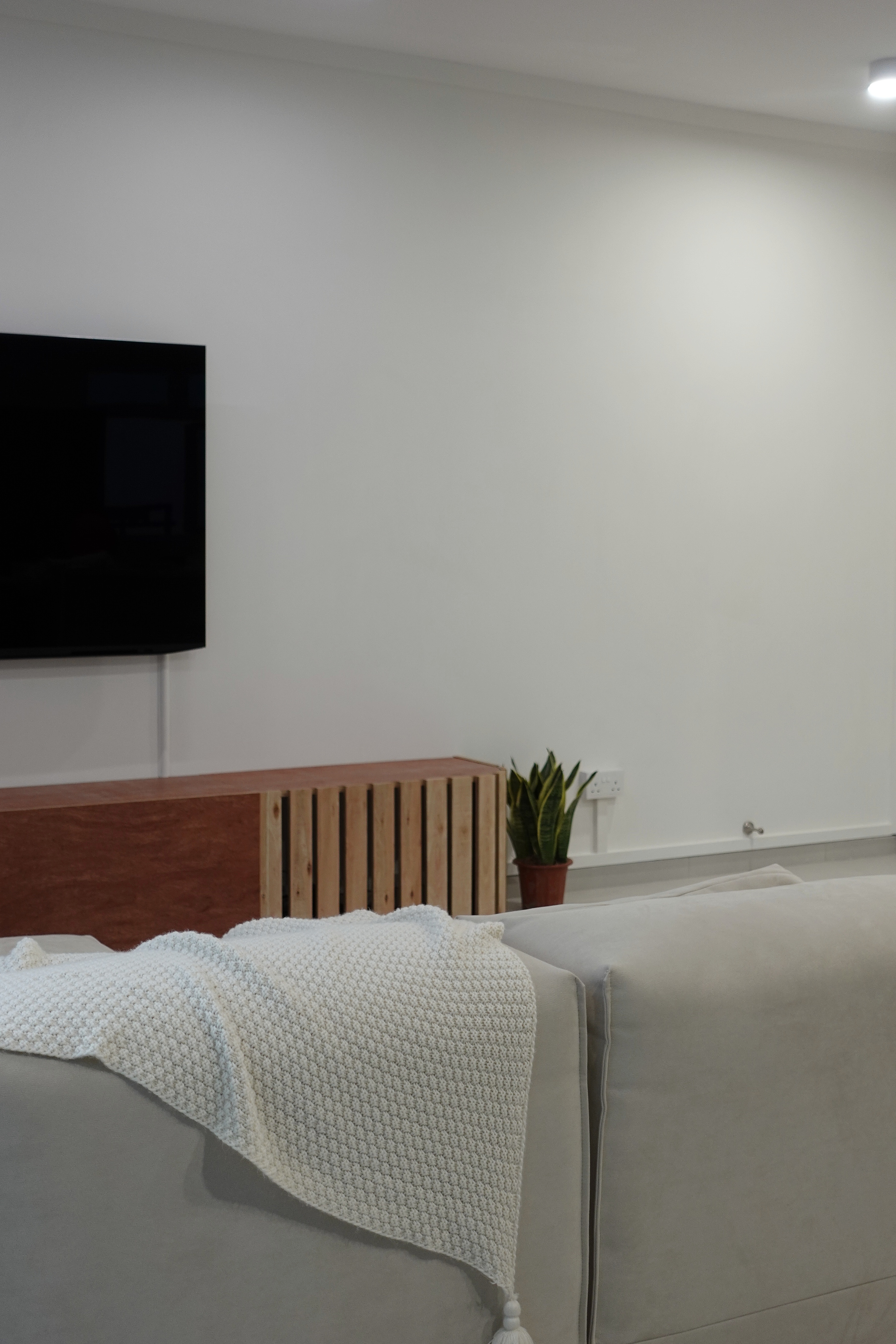 A minimal living room with a full out DIY TV console - Modern living room, minimalist decor, white walls, cozy ambiance