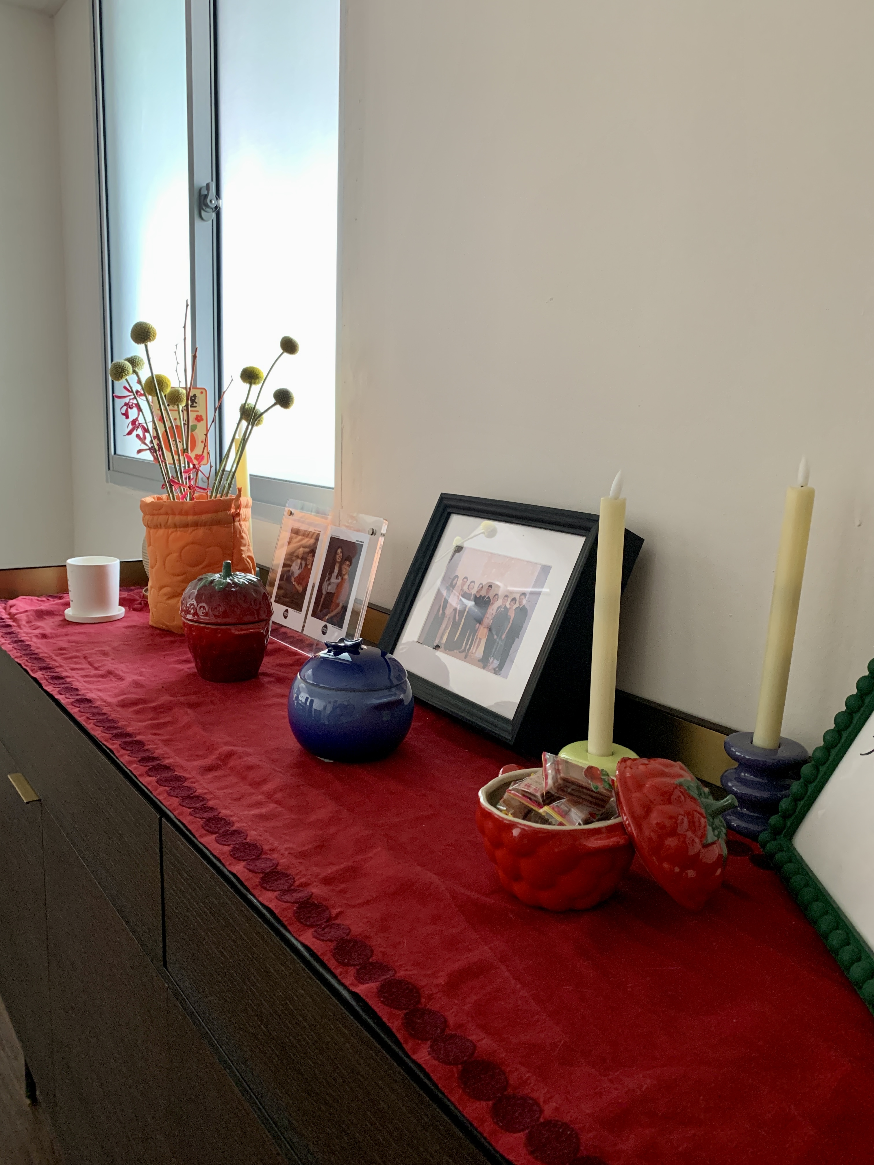 Welcoming the Year of the Dragon - Hanging Lanterns Everywhere - vibrant candles, red tablecloth, orange vase, green flowers