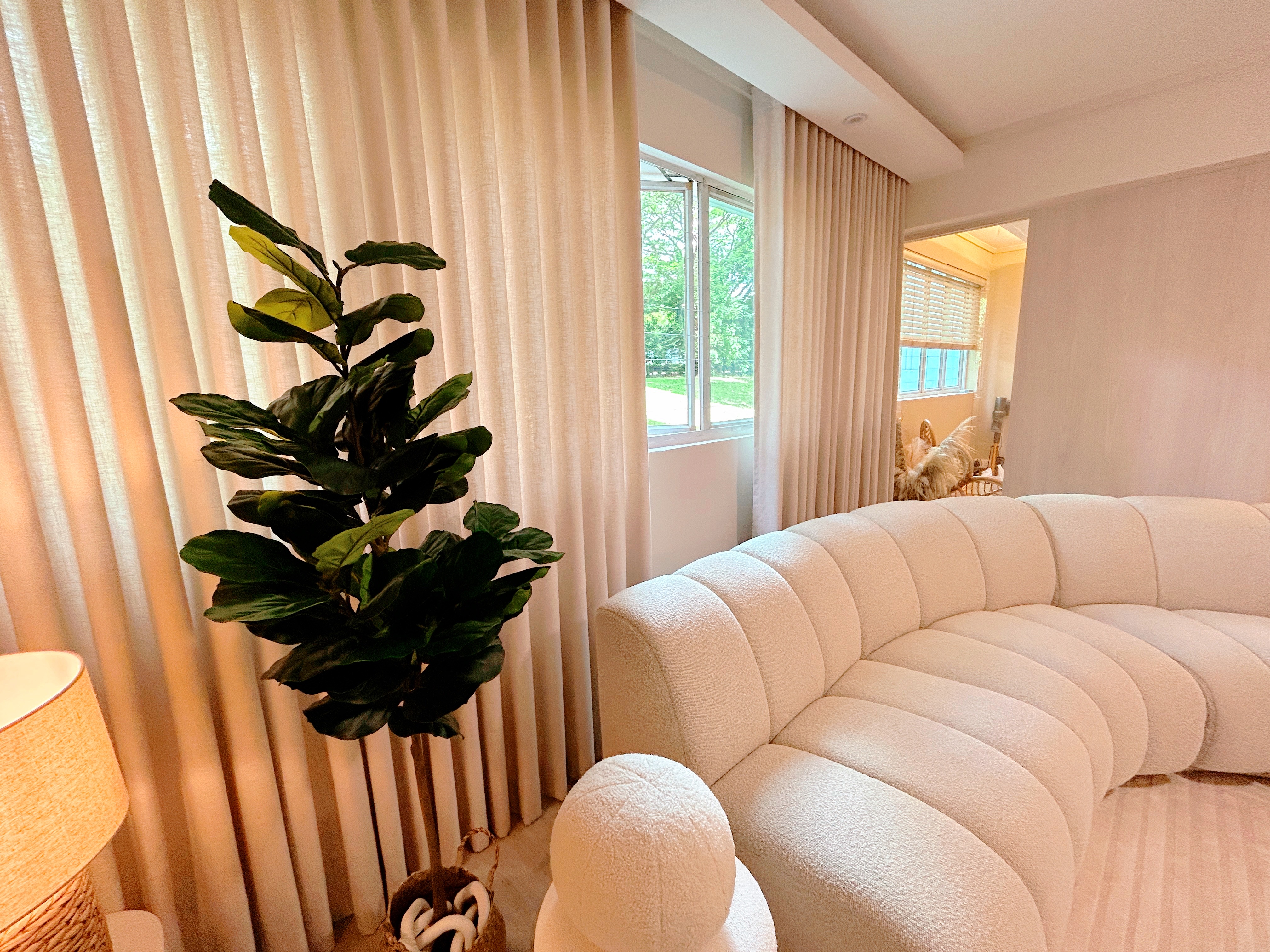 Living Room: Chill and Netflix! - Cream-colored plush sofa, cream-colored curtains, large green plant, beige lampshade, cozy