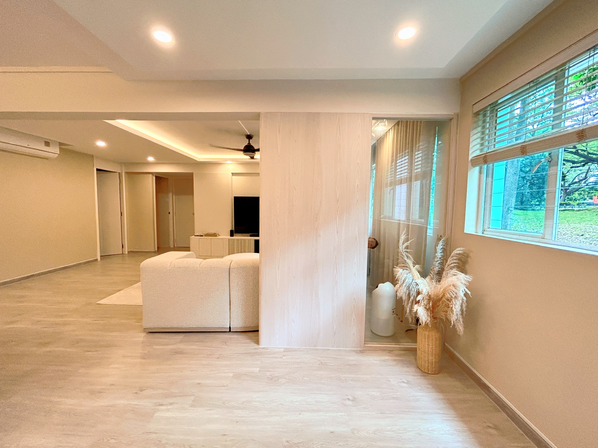 Entryway/ Balcony Transformation! - Modern living room with beige walls, wooden flooring, and large windows with blinds.