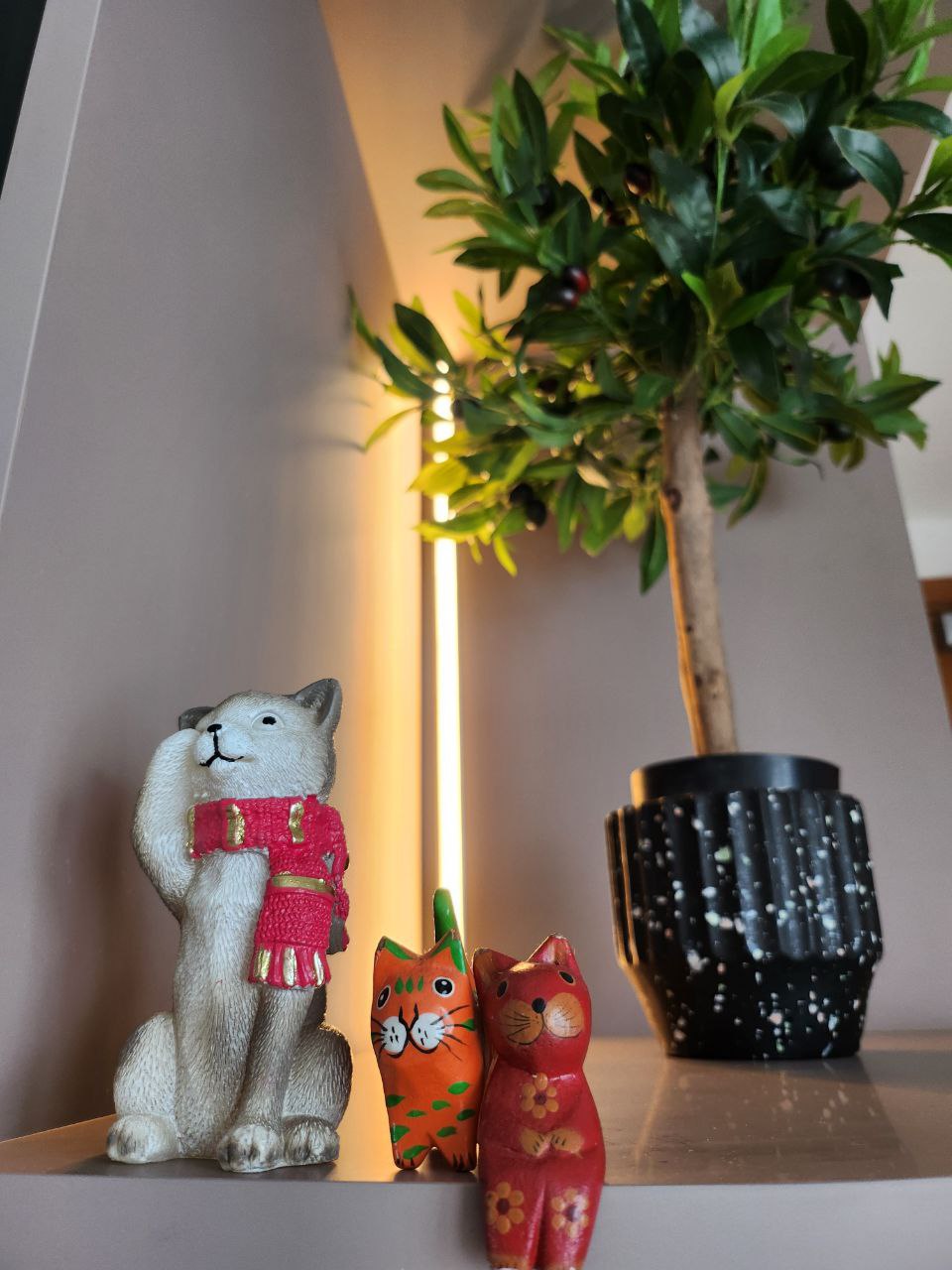 Green Babies: real or faux? - White cat figurine dressed in red traditional attire, Orange cat figurine with green accents