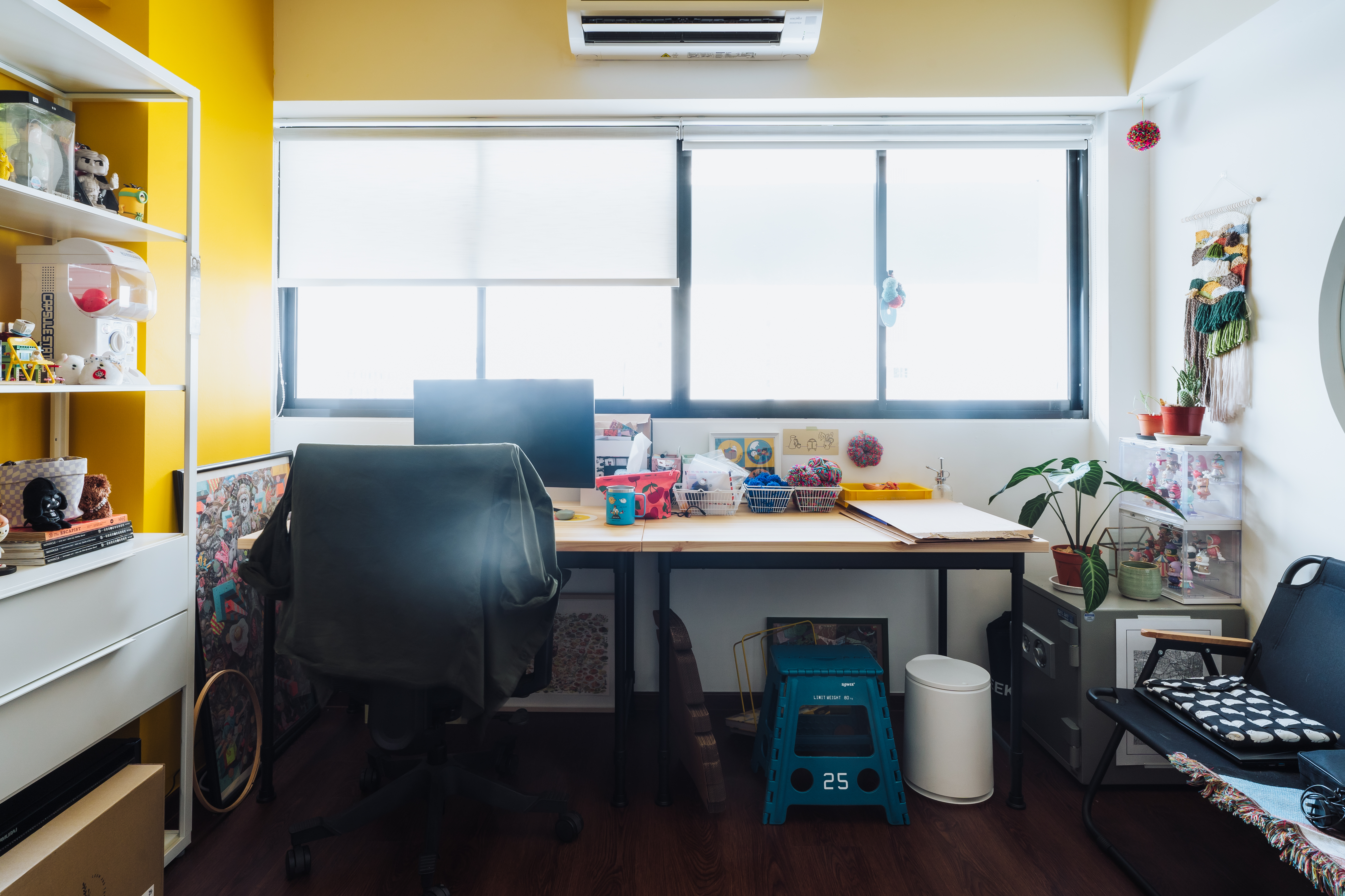 Studio - A bright pop of yellow and a whole lot of knick-knacks!  - Bright yellow walls, white shelving unit, window with