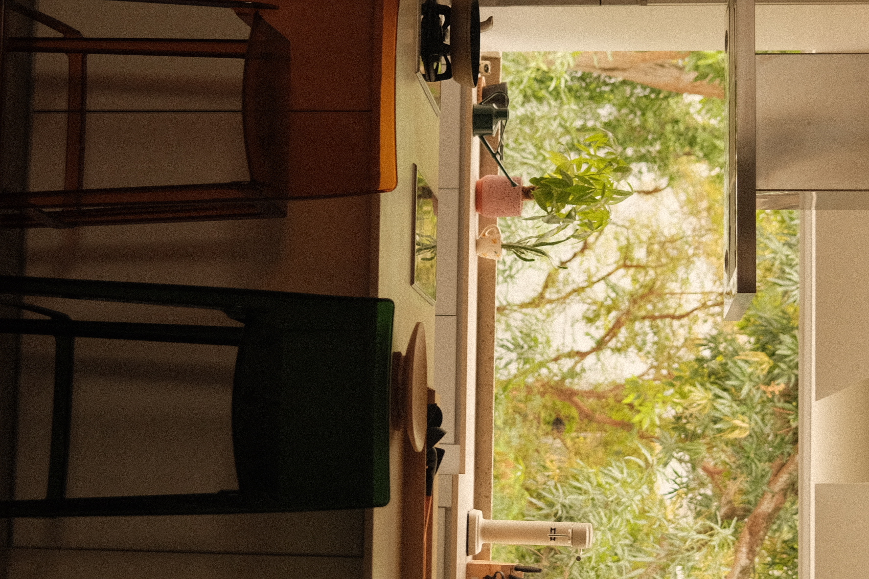 Open kitchen overlooking a green oasis! - Modern kitchen interior, cozy atmosphere, natural light streaming, wooden cabinets