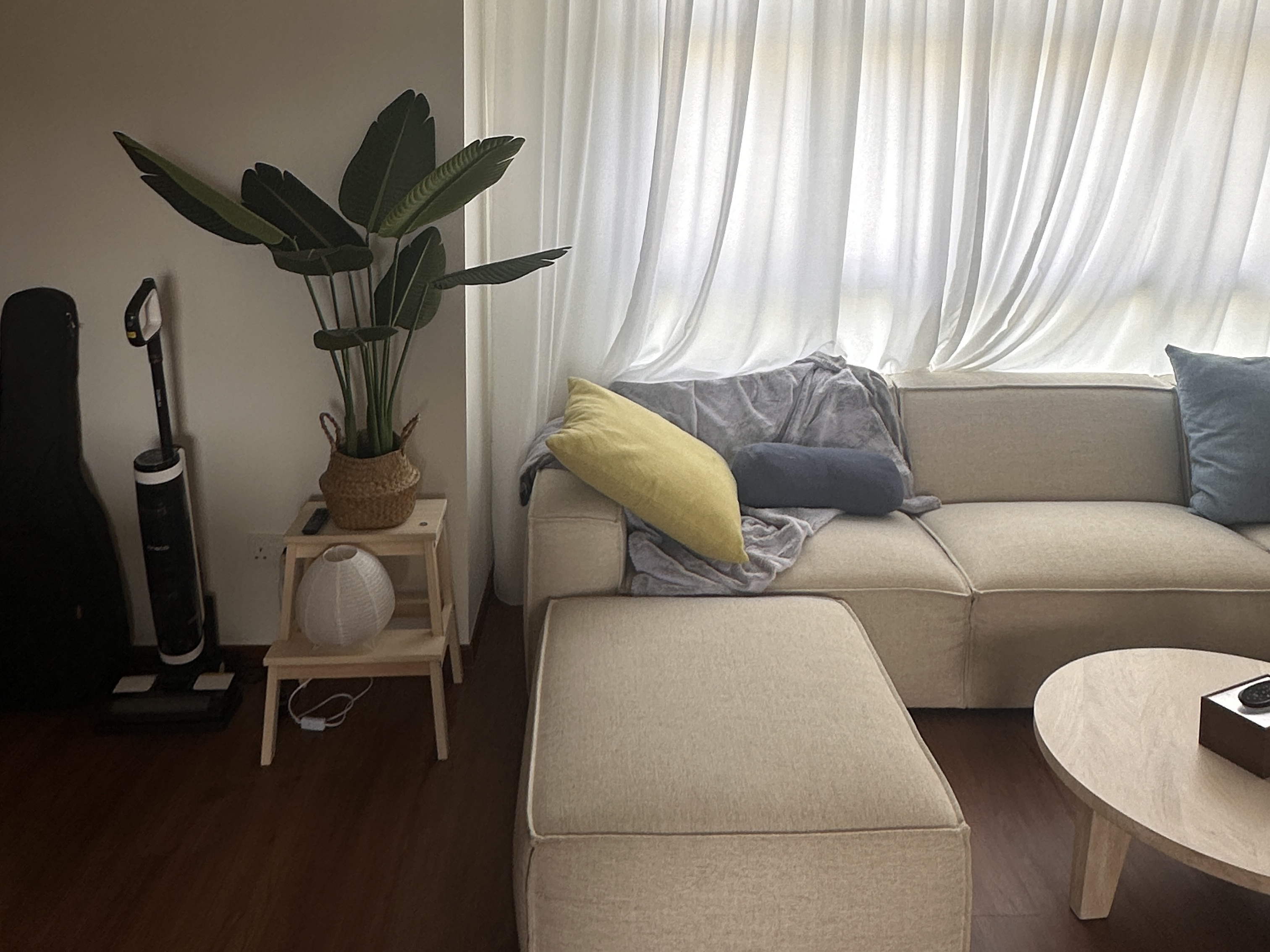 Minimalist yet functional home under $45k - Modern living room, cozy seating area, beige sofa, gray throw blanket, yellow