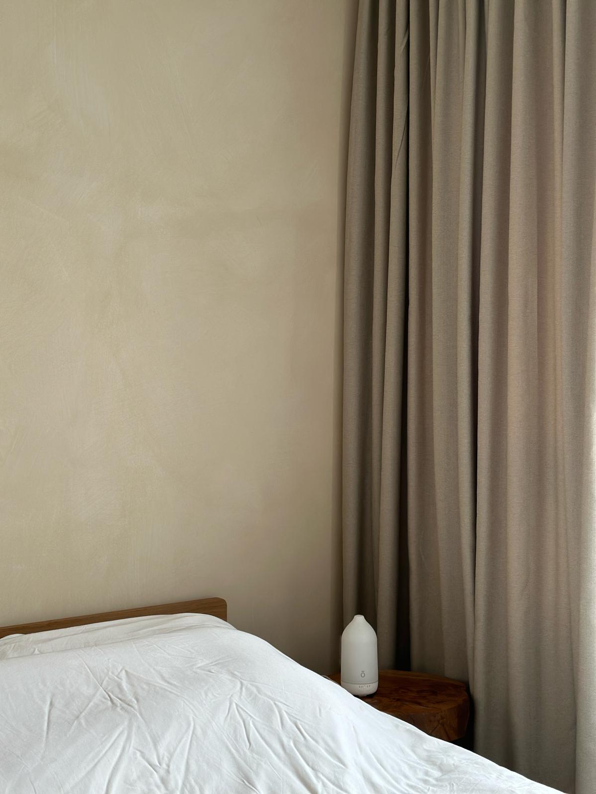 Japandi and wabi-sabi master bedroom  - Creamy beige wall, soft natural light, minimalist design, cozy bed, white comforter