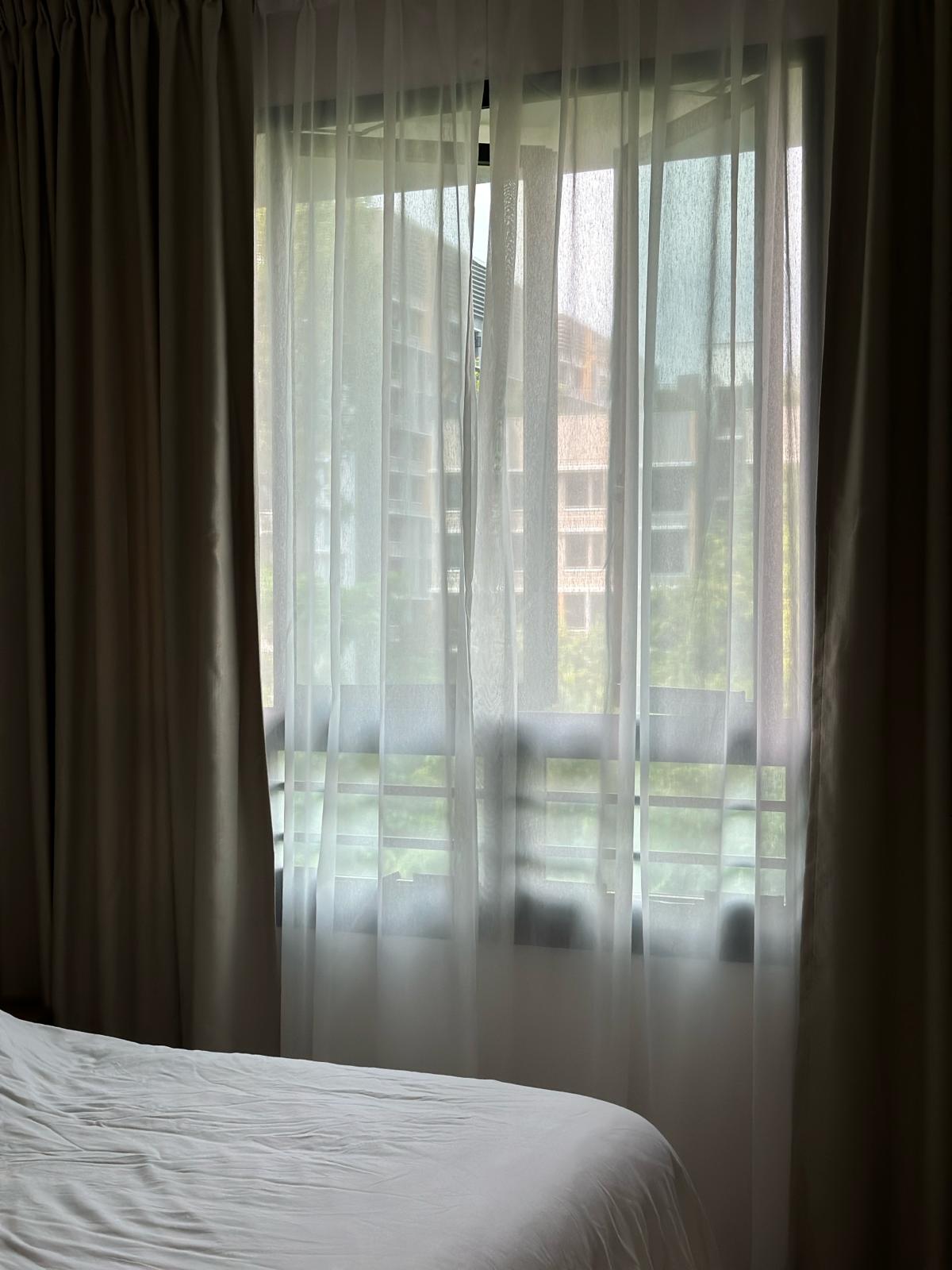 Japandi and wabi-sabi master bedroom  - Gentle morning light filters through sheer curtains, softly illuminating a neatly