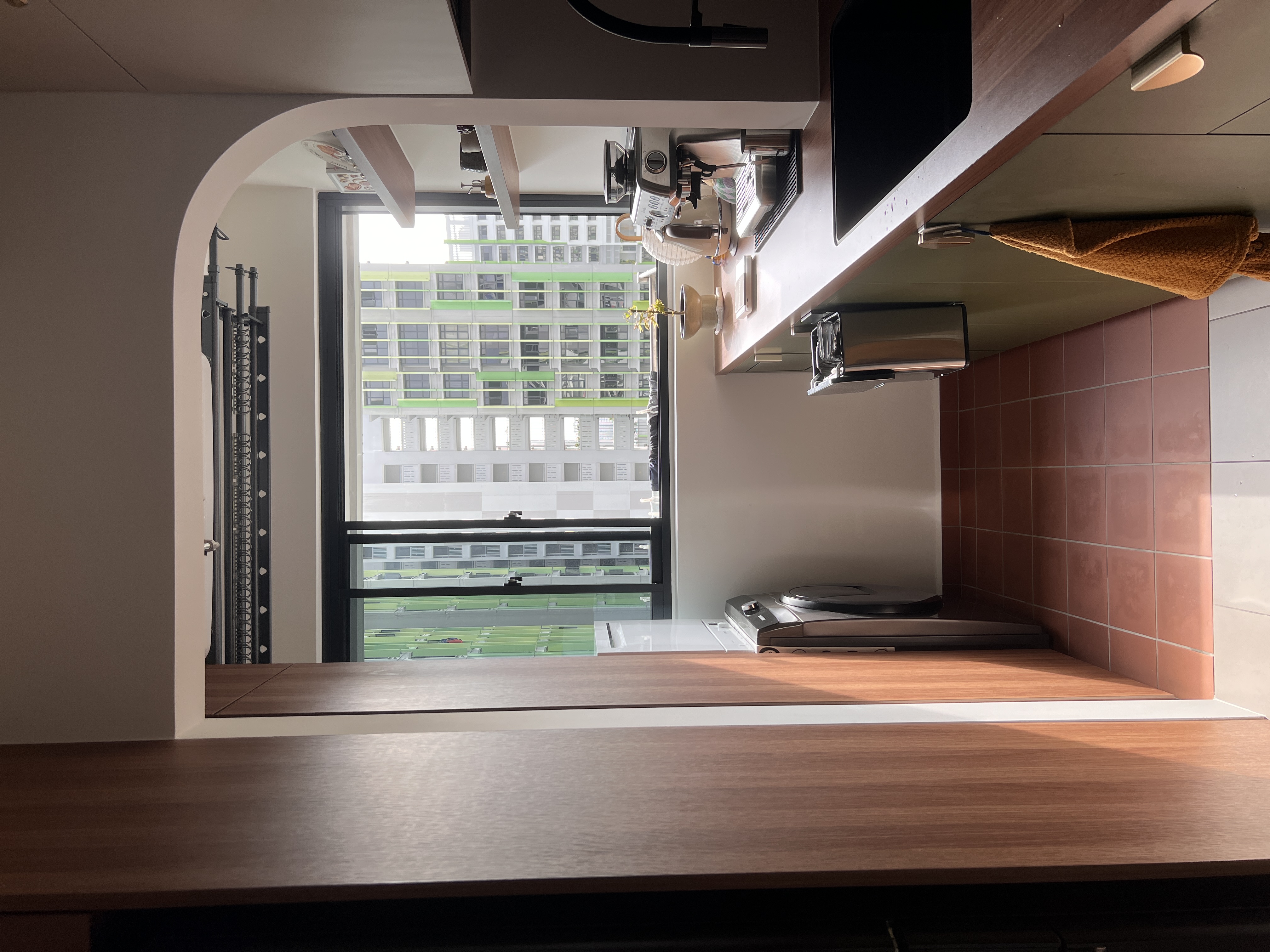 The yard that services the home - Modern kitchen with sleek design, large window, brown tiled walls, wooden countertop