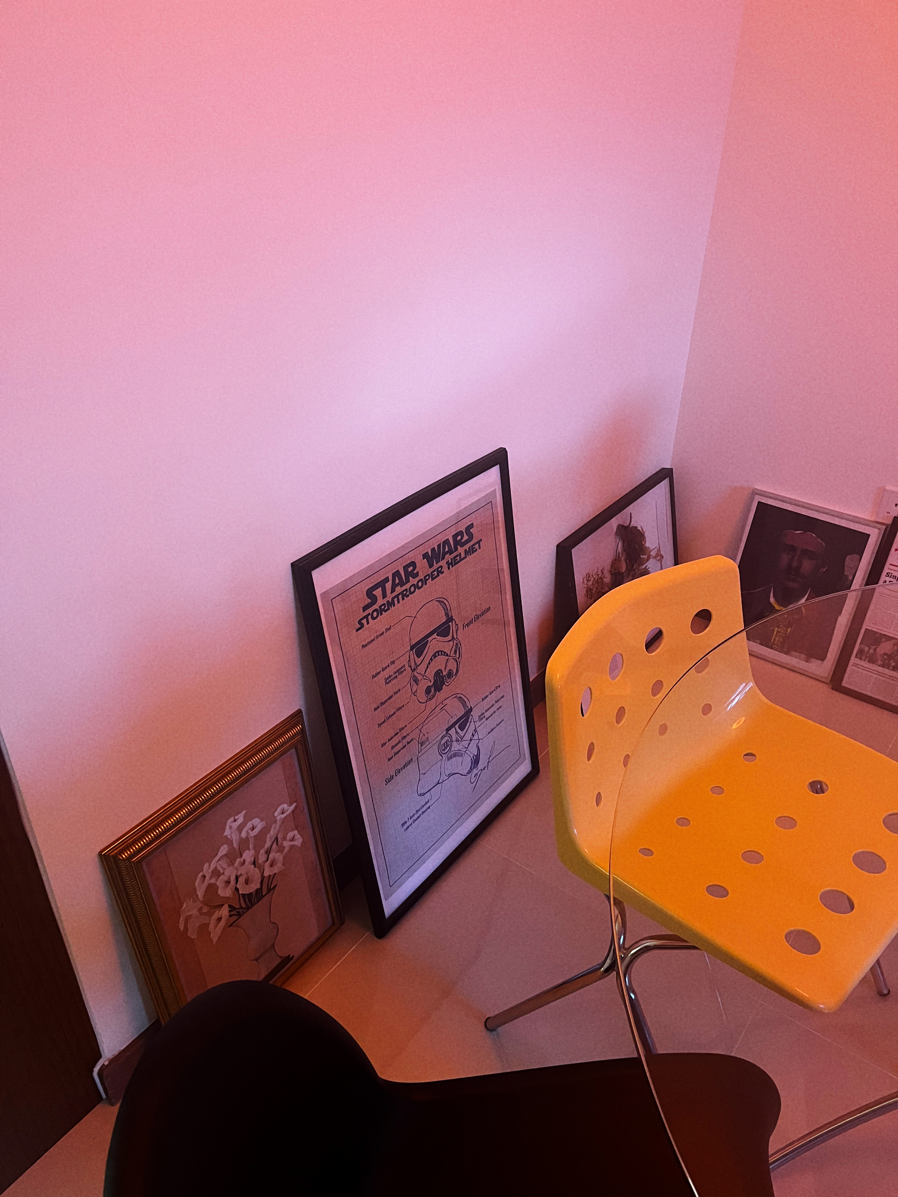 A retro and playful home - Pink wall, framed Star Wars posters, Stormtrooper helmet, Darth Vader, "Star Wars Trooper Helmet"