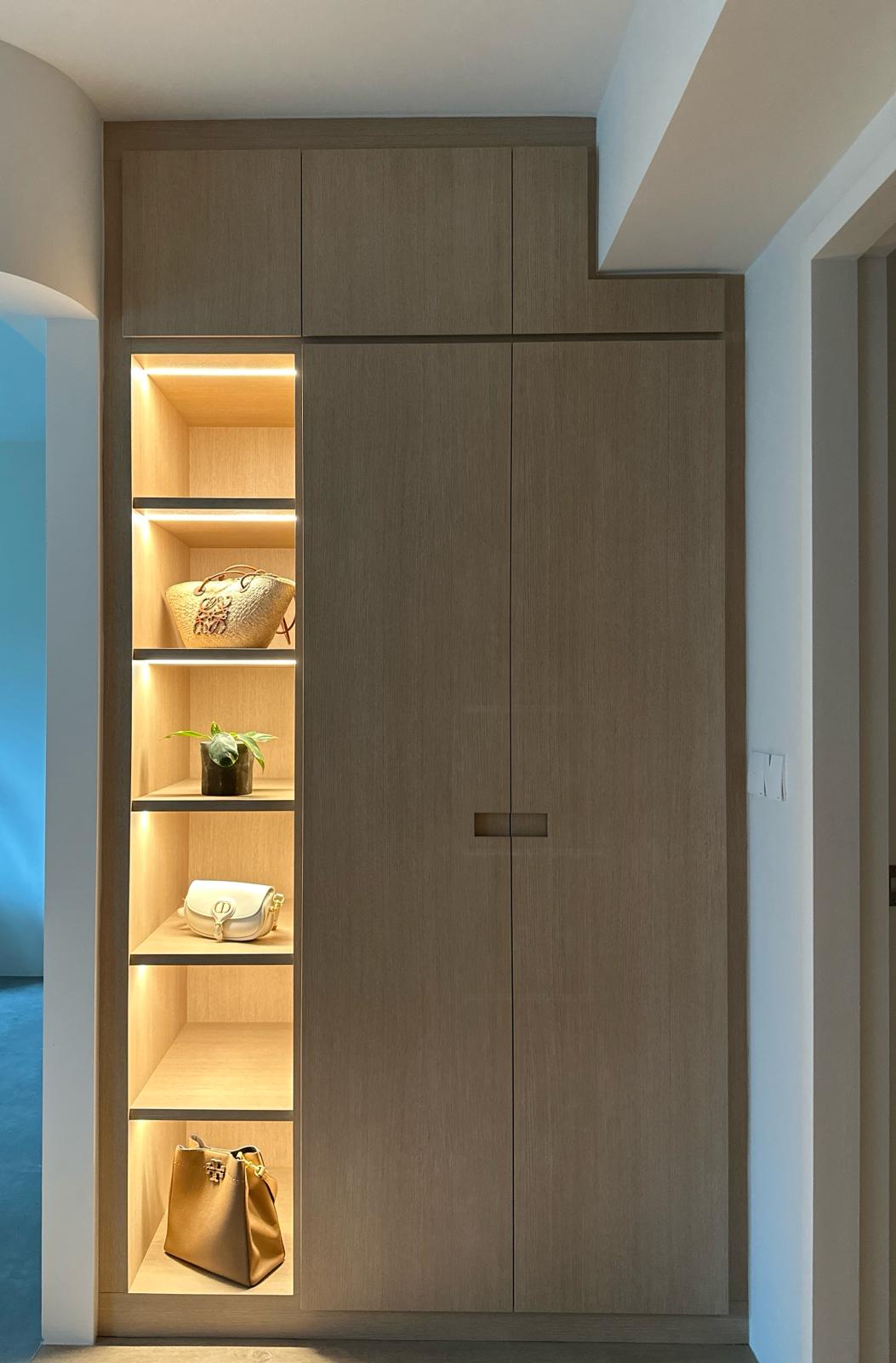 Our mini walk-in wardrobe in master bedroom  - Wooden wardrobe with illuminated shelves, showcasing various bags and plants