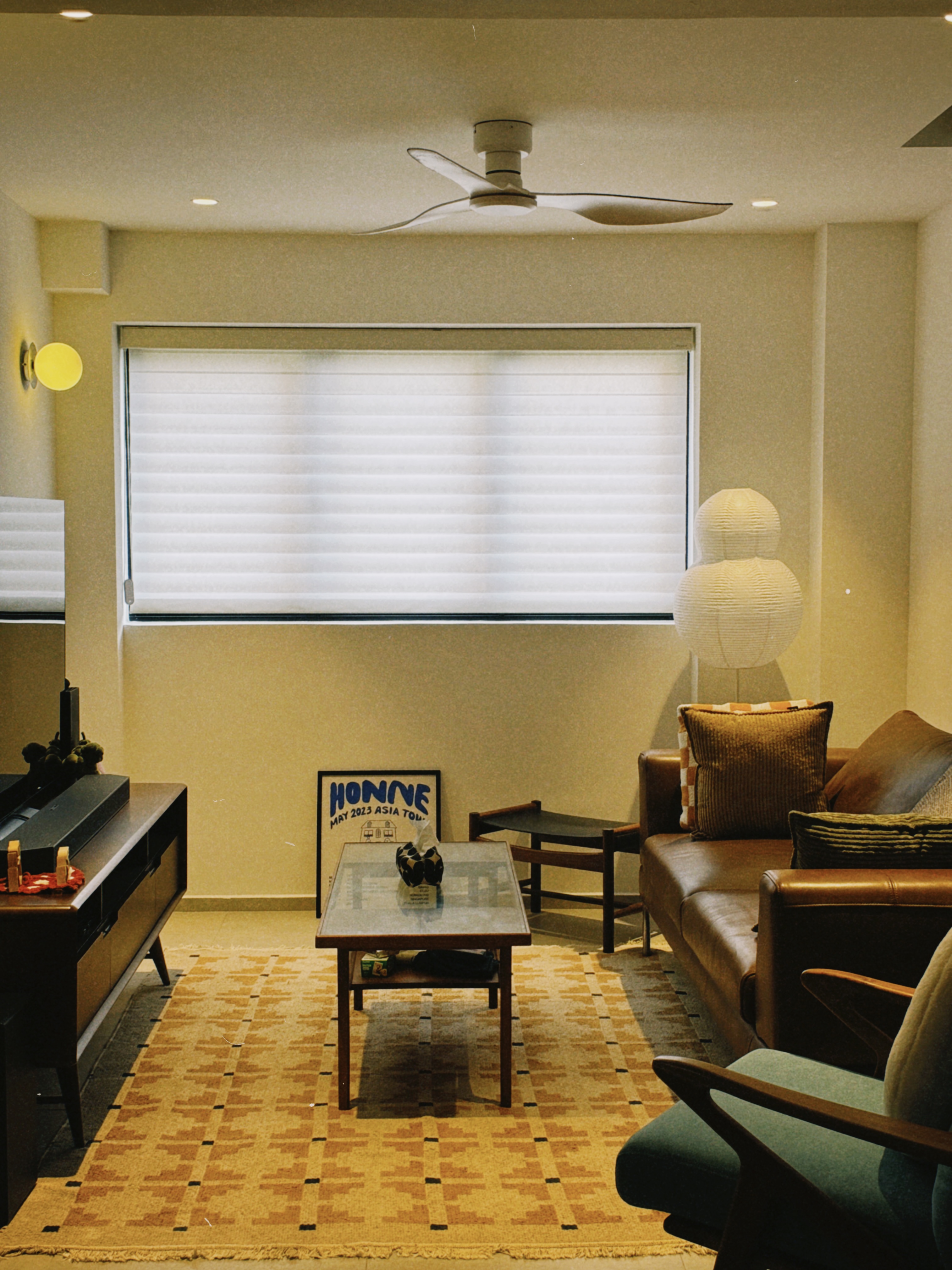 A Mid-Century Modern Home with Wood, Warmth and Colours - Modern living room with large window, beige walls, patterned rug