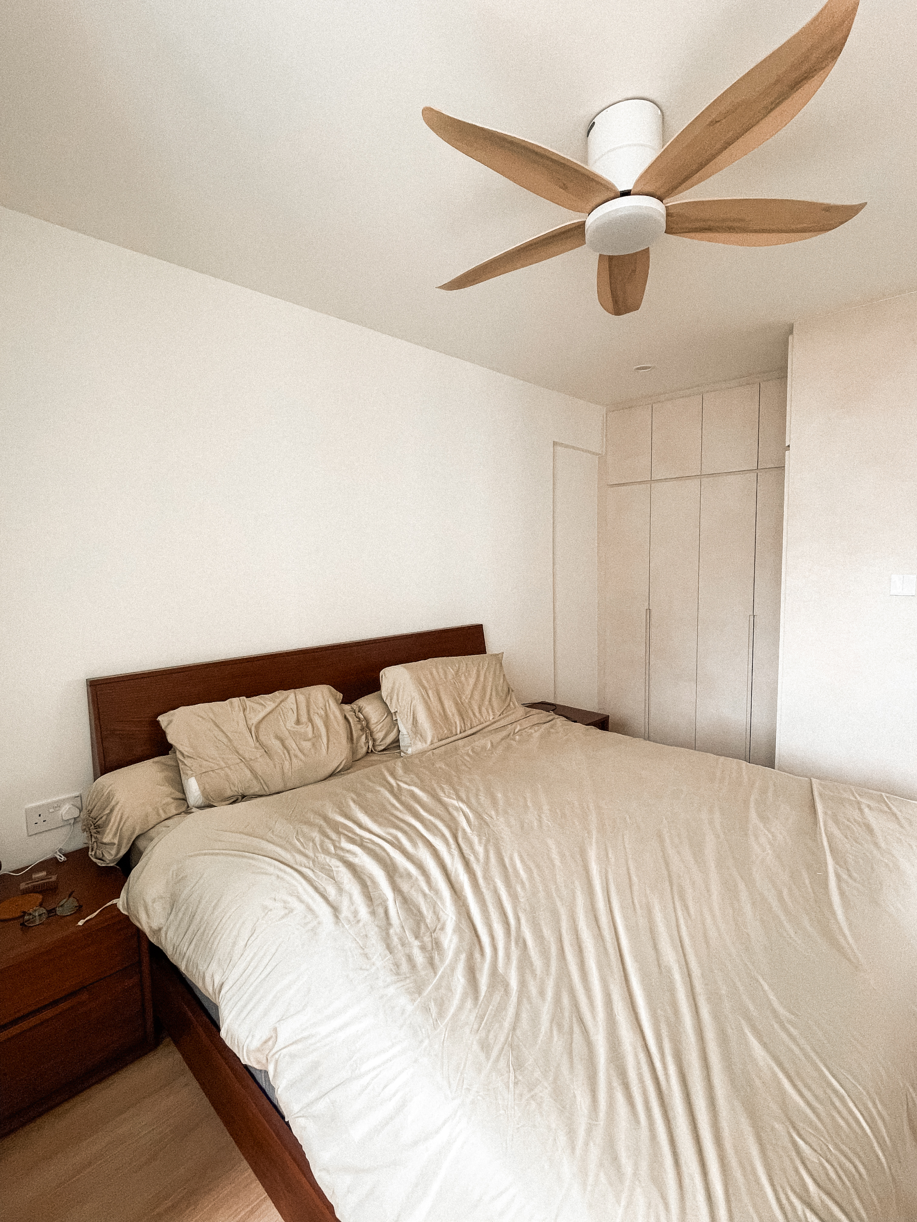 Welcome to our Littleroot House! - Wooden ceiling fan, beige bedding, wooden nightstand, minimalist decor, white walls