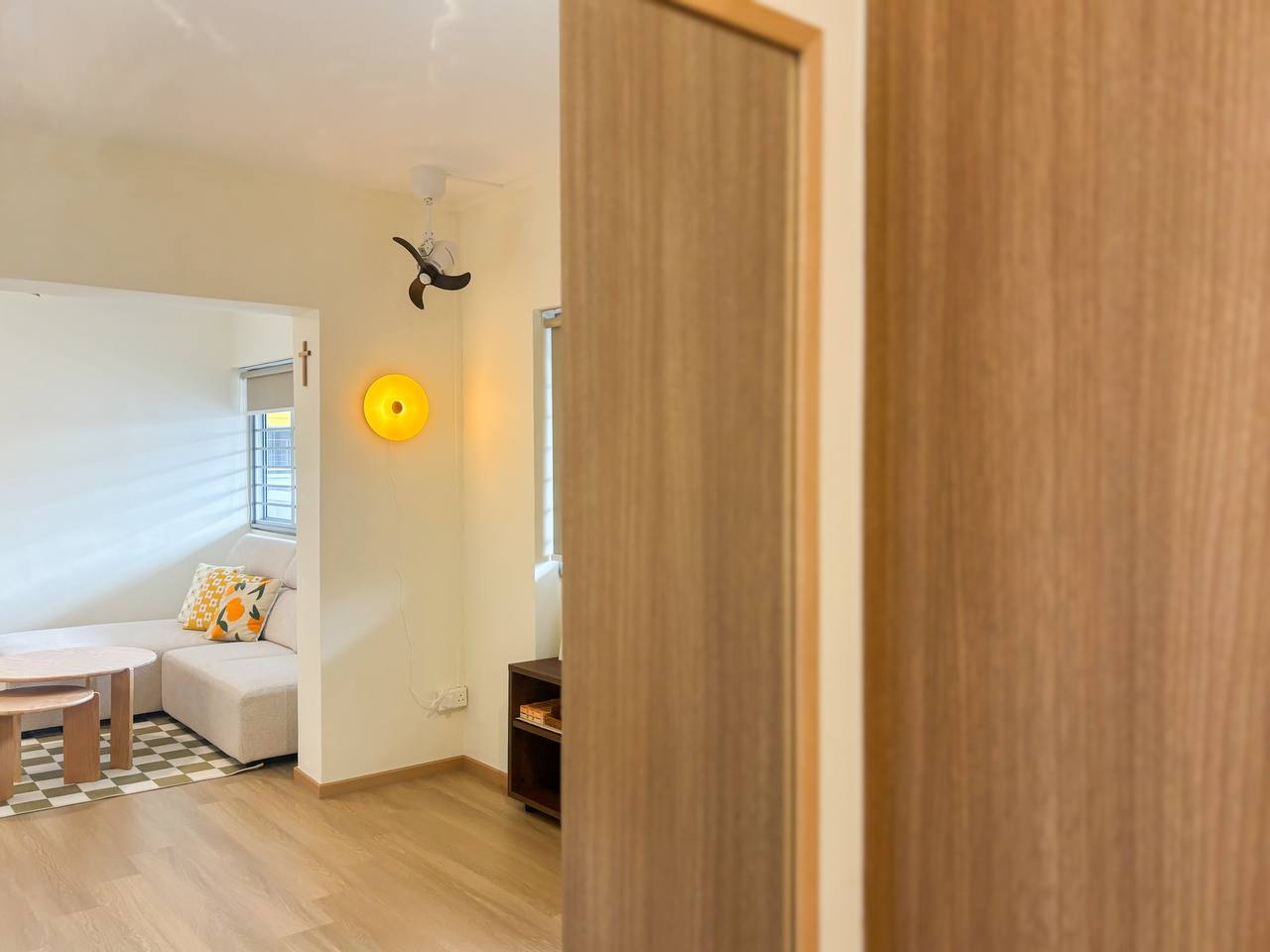 He wants it minimal, she wants it cute - Modern living room with wooden flooring, beige sofa, geometric patterned cushions