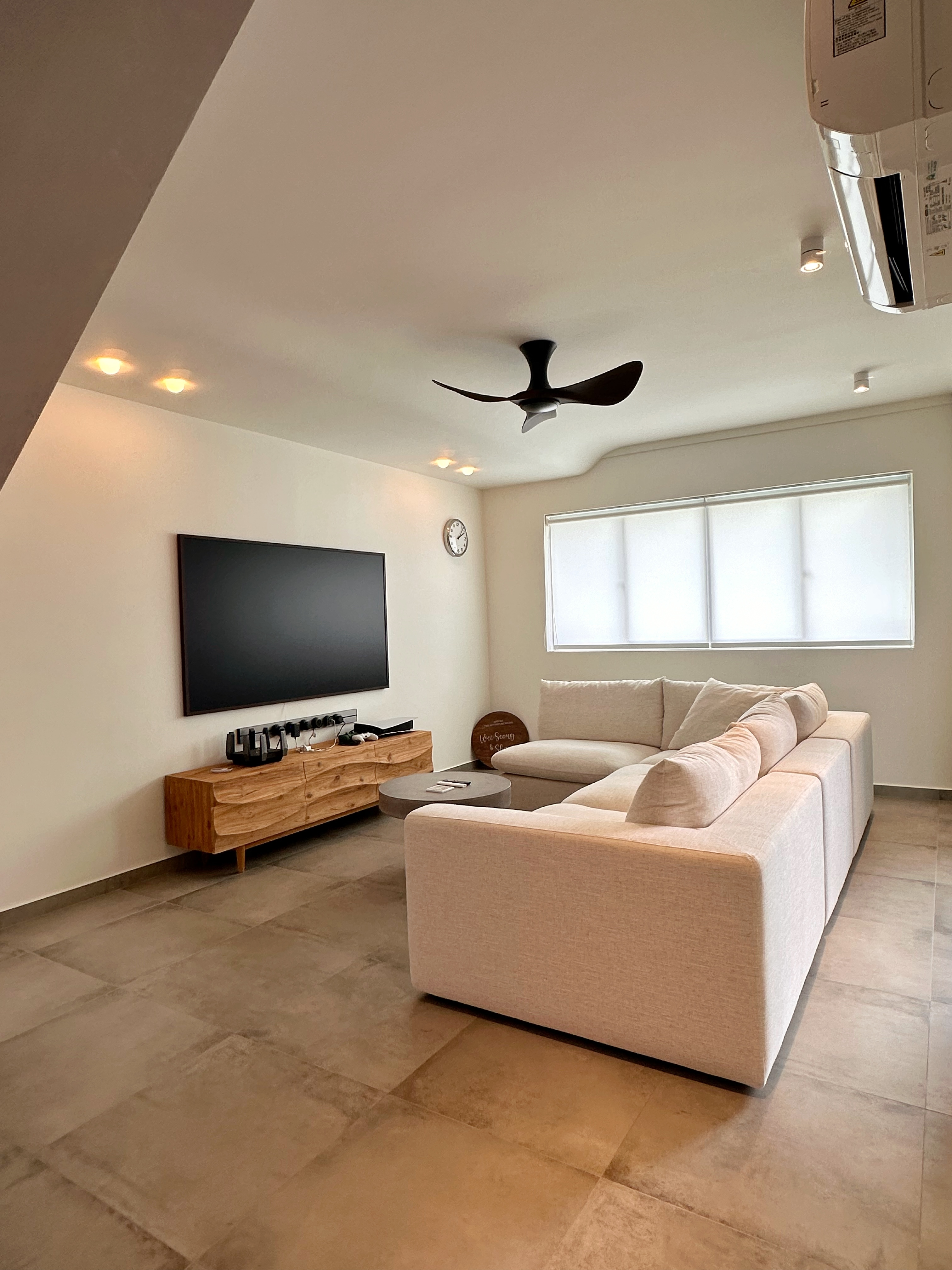 When Industrial meets Wabi-Sabi details within 1593sqft. - Modern living room with beige sectional sofa, large flat-screen TV