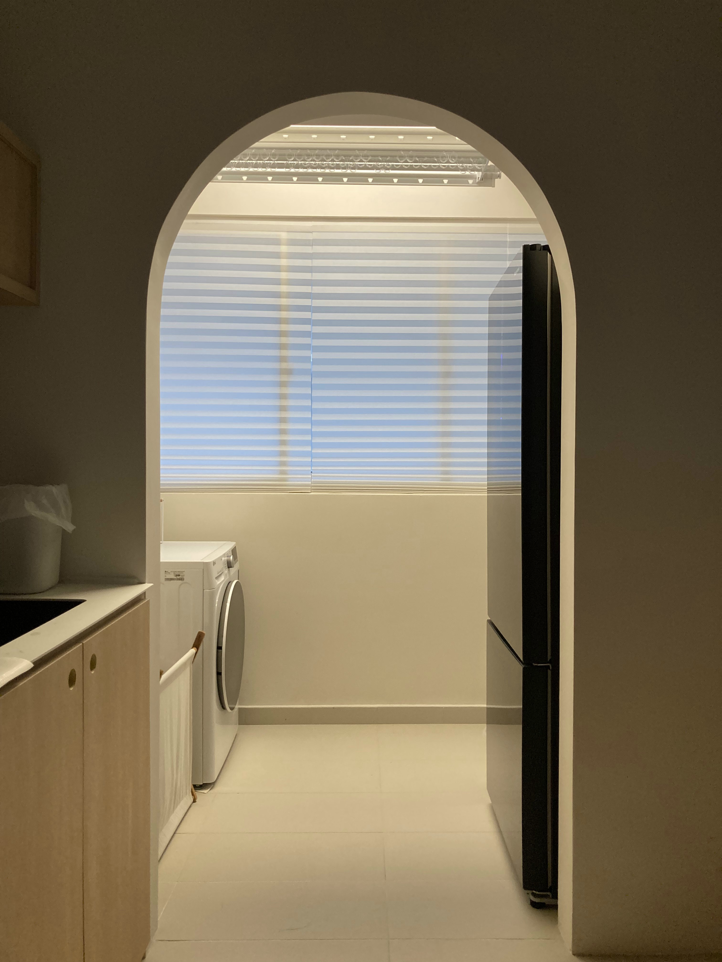 Service yard with a fridge and zero built-ins - Kitchen with washing machine and refrigerator, arched doorway, light-colored