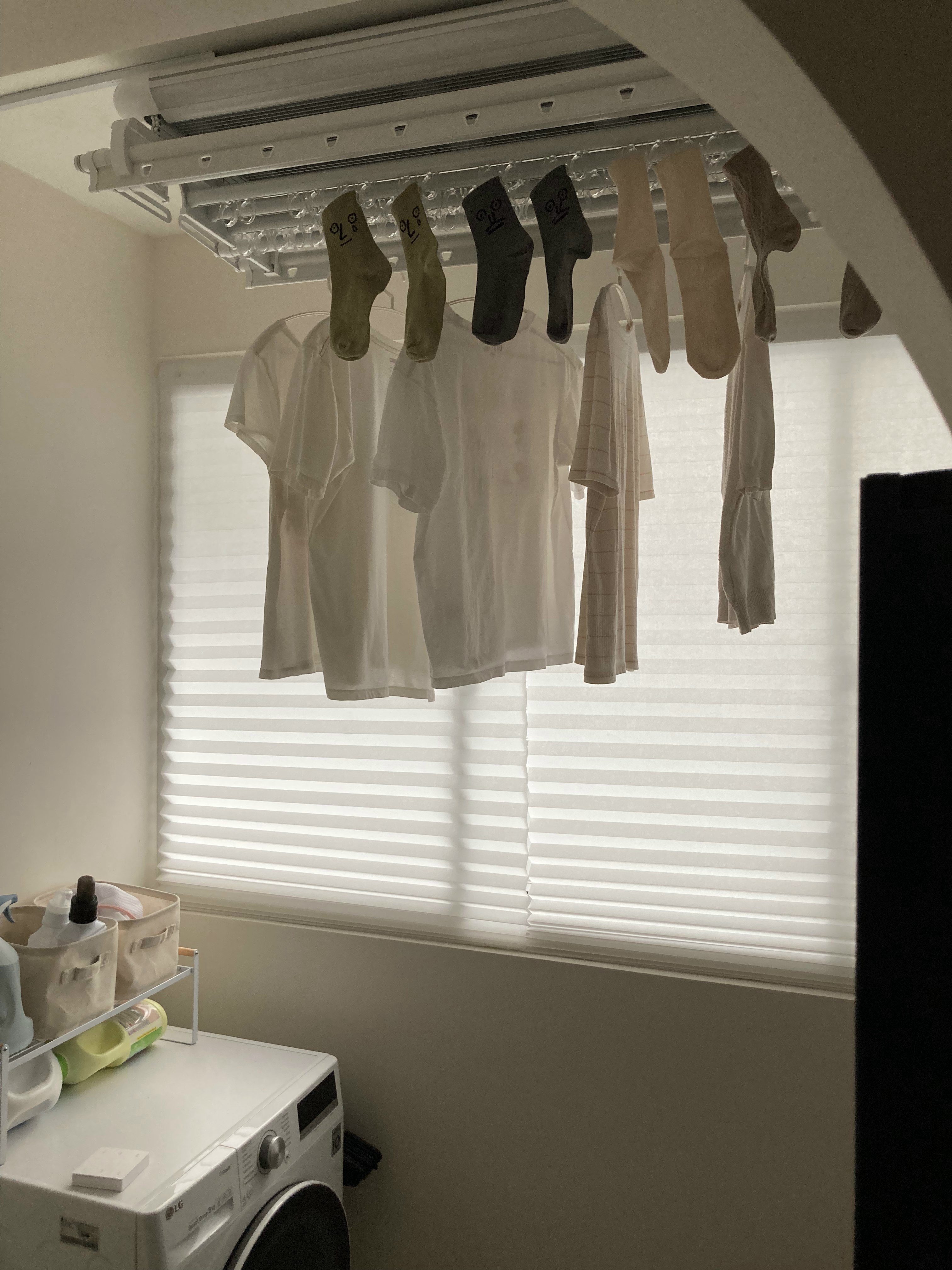 Service yard with a fridge and zero built-ins - White laundry basket, white washing machine, window blinds, light streaming
