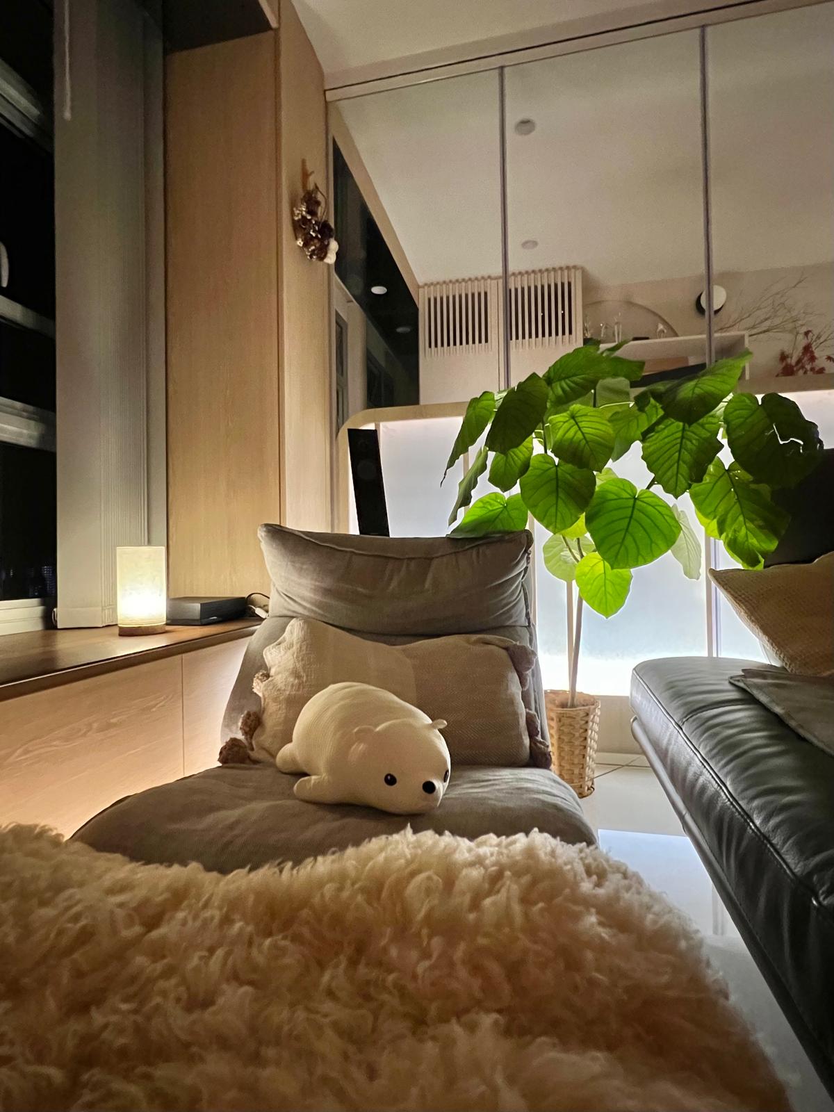 The Power of Lighting | Day and Night View of Living Room - Lush green potted plant, cozy armchair, plush beige rug, soft