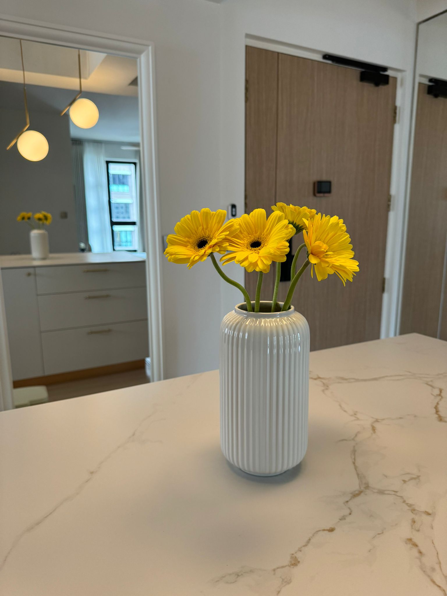 Flat white and gold modern minimalist 4rm resale HDB - vibrant yellow flowers in white vase, modern kitchen interior