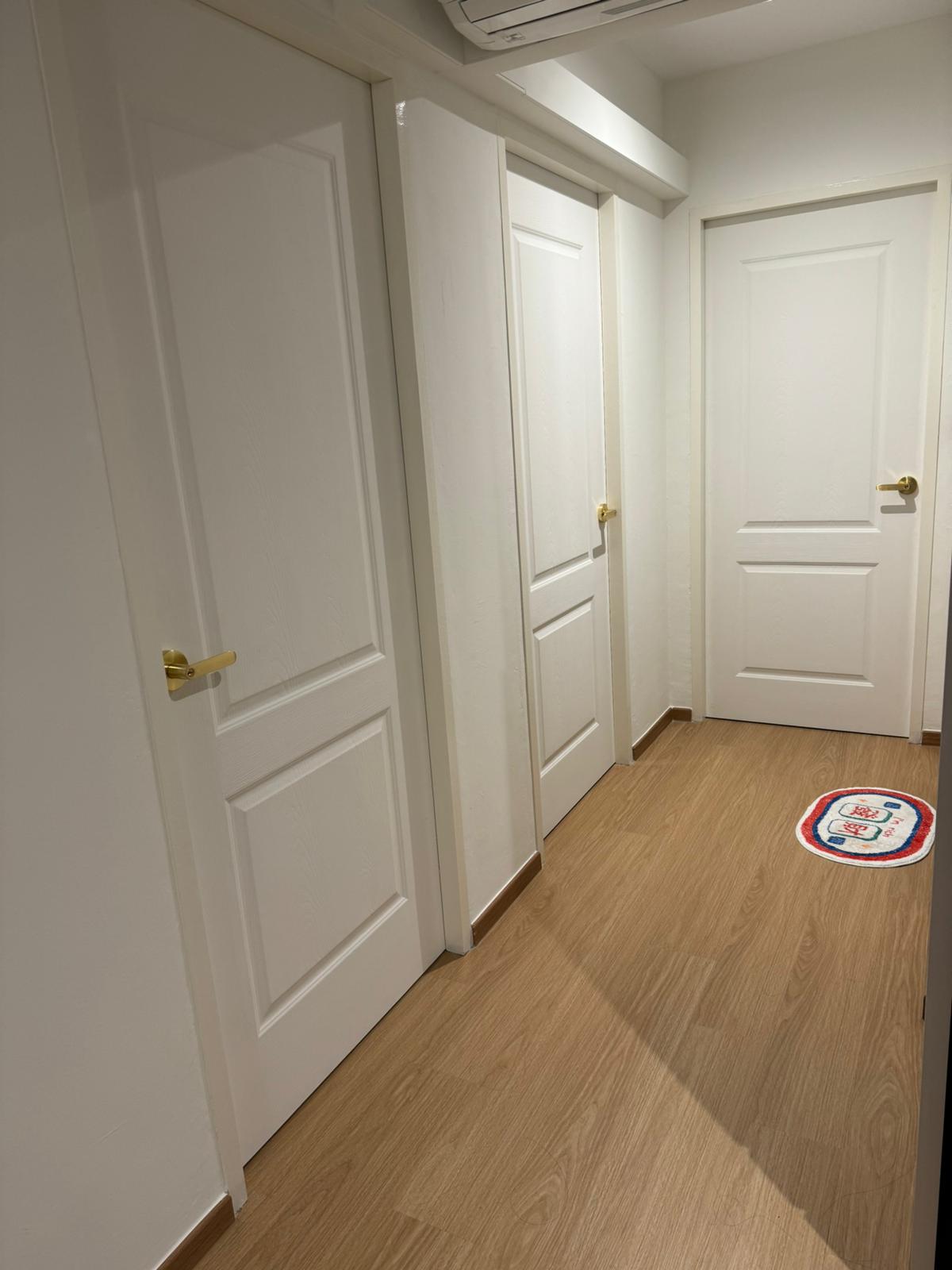 Flat white and gold modern minimalist 4rm resale HDB - White door with brass handles, wooden floor, minimalist hallway, three