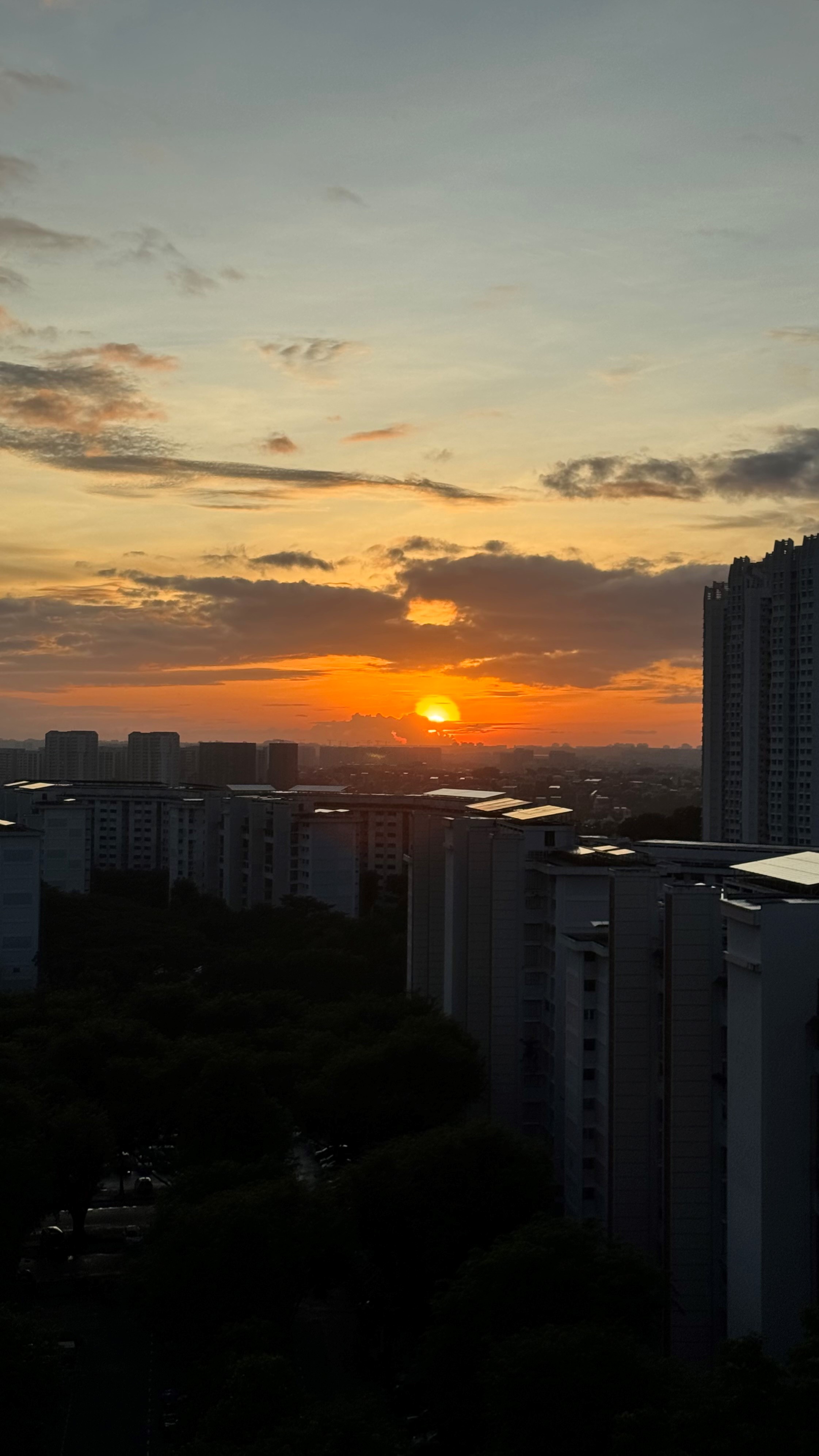 Unveiling The Littlestarry Loft - Sunset over cityscape, tall buildings silhouetted against vibrant sky, warm orange and