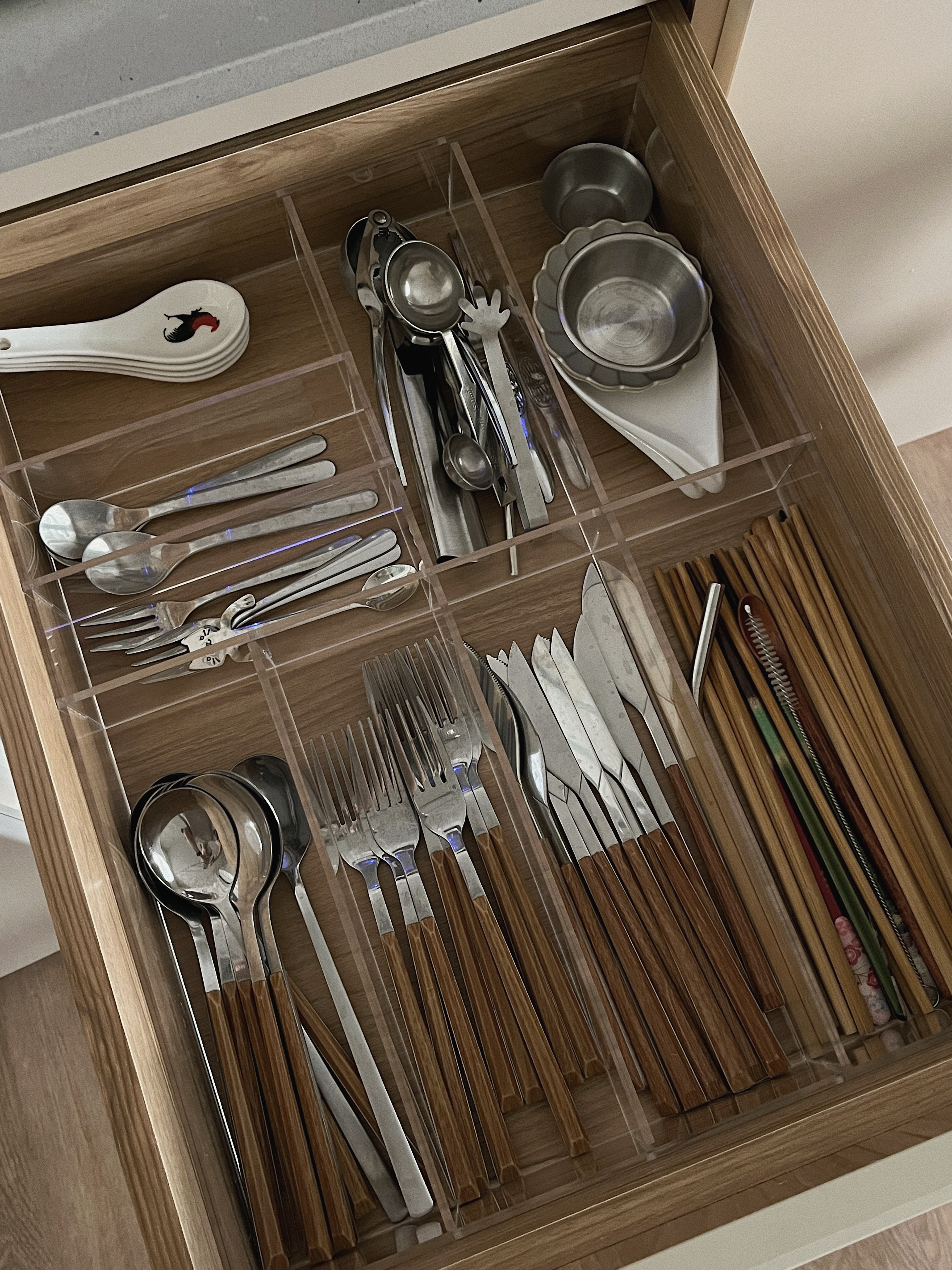 Scandi Kitchen - Keeping it minimal & light - Clear glass drawer, neatly organized utensils, stainless steel spoons, wooden