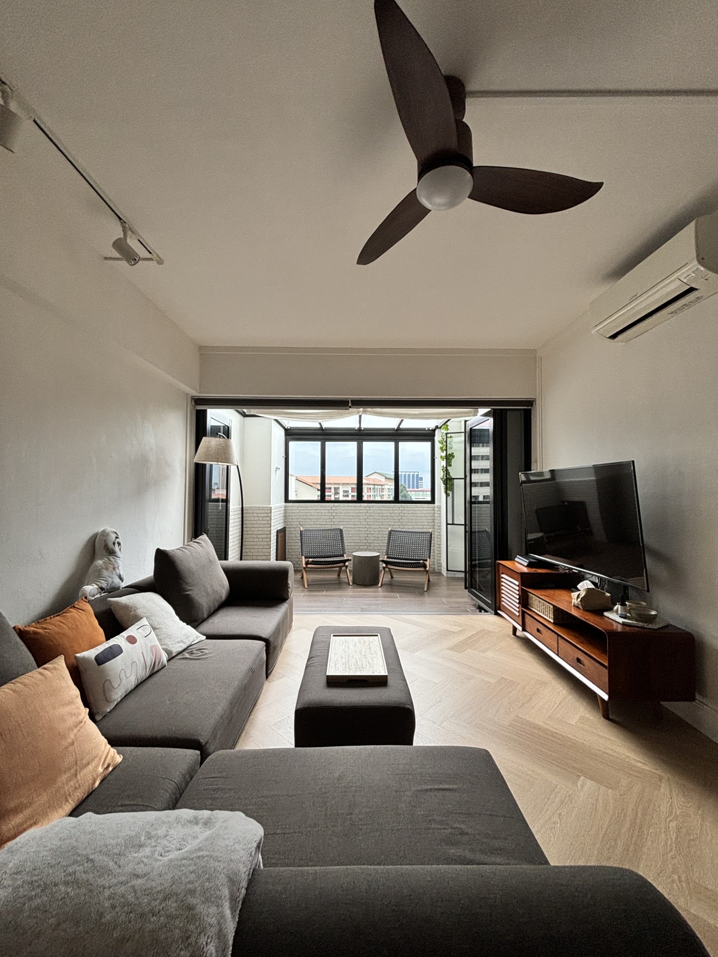 Warm & Cosy HDB Maisonette - modern living room, cozy seating, gray sectional sofa, orange throw pillow, wooden coffee table