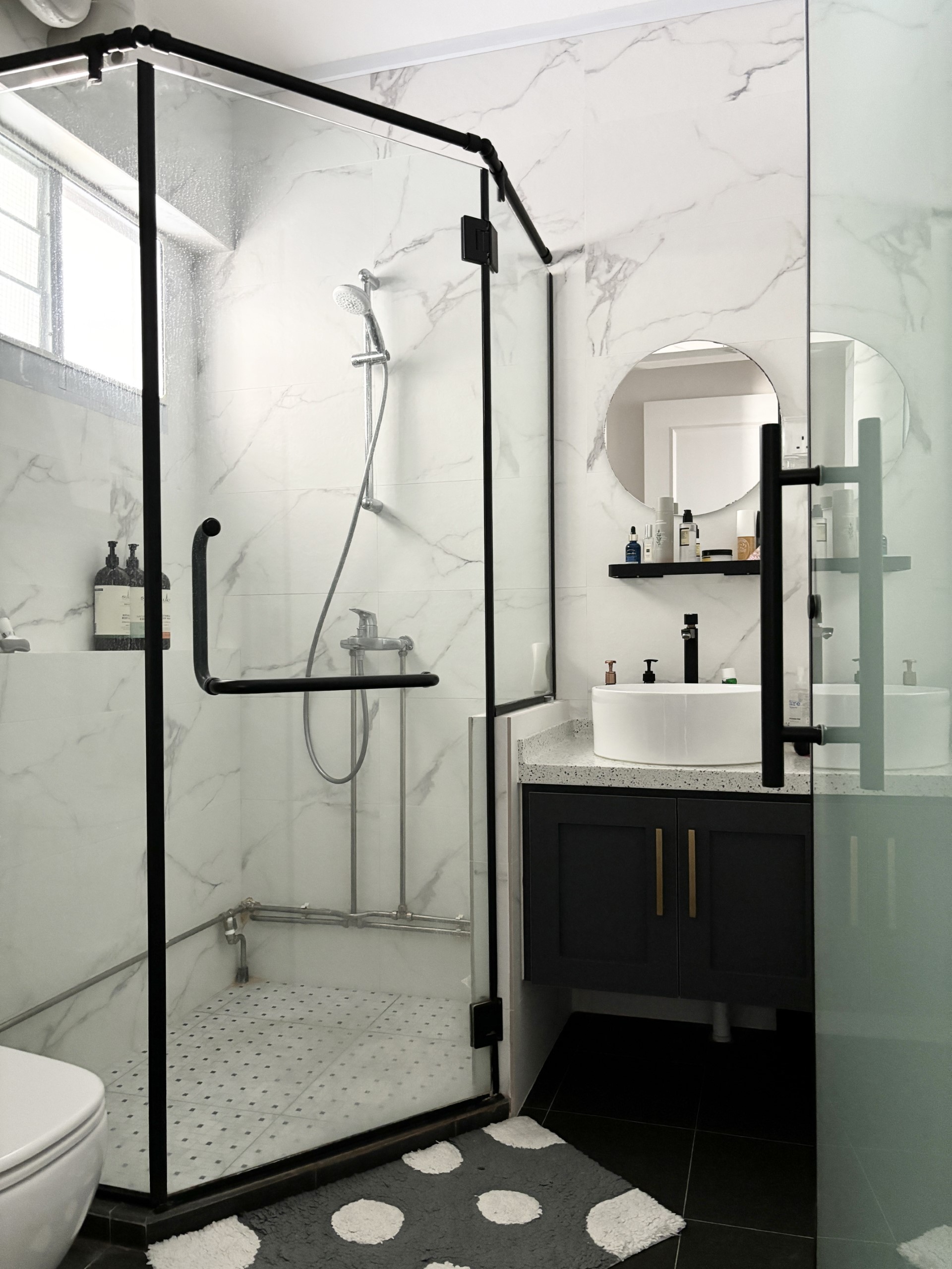 Warm & Cosy HDB Maisonette - Glass-enclosed shower with black frame, marble walls, modern design, white and gray color