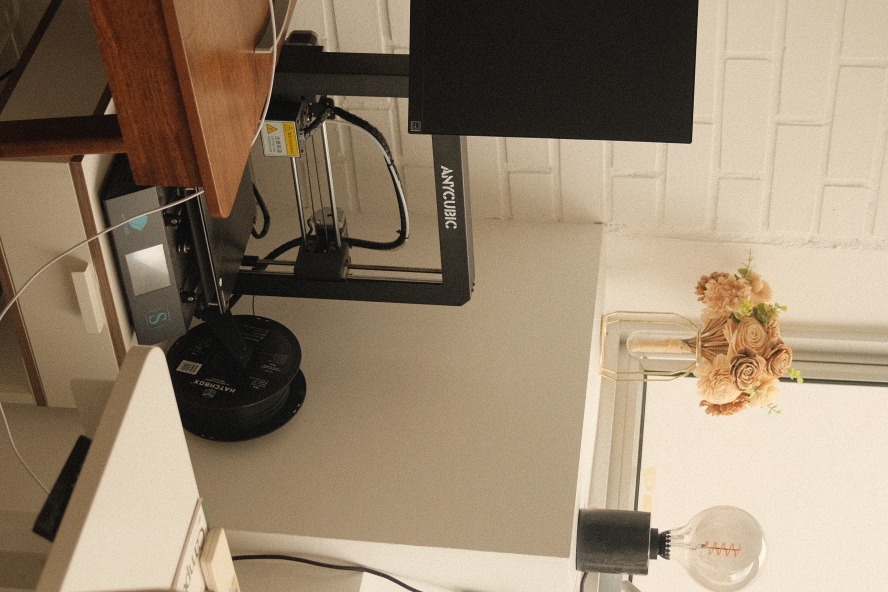 Our 2 person study with a few creative outlets to keep us inspired - 3D printer on wooden desk, black Anycubic printer