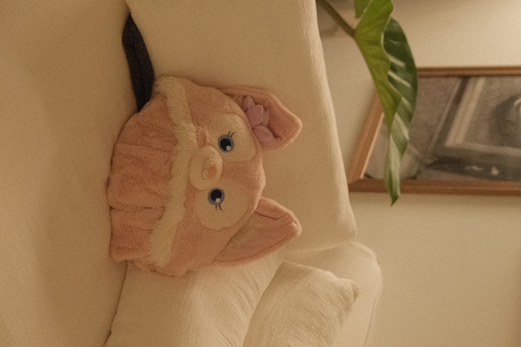 Our cozy corner in an eclectic home - Soft, pink plush toy with big blue eyes, sitting on a white pillow, featuring a cute