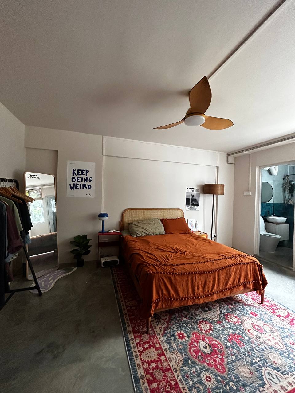 Welcome to our eclectic and hobo themed home in the East - Cozy bedroom with a large bed and orange bedding, Hanging clothes