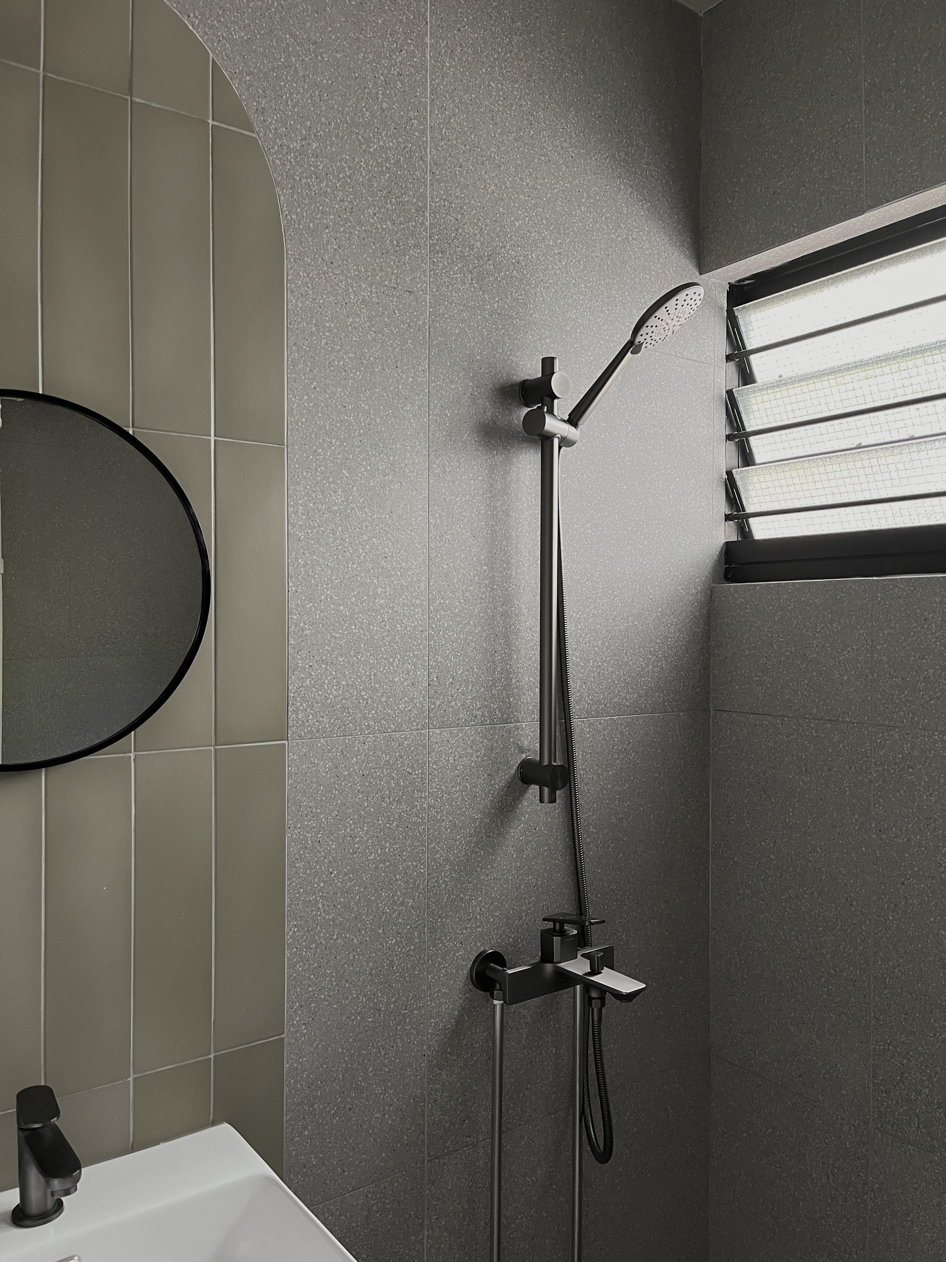 Bathroom - Relaxing Hotel Vibe (Pretty in Pink 🩷) - Grey tiled wall, modern showerhead, black handle, black hose, circular