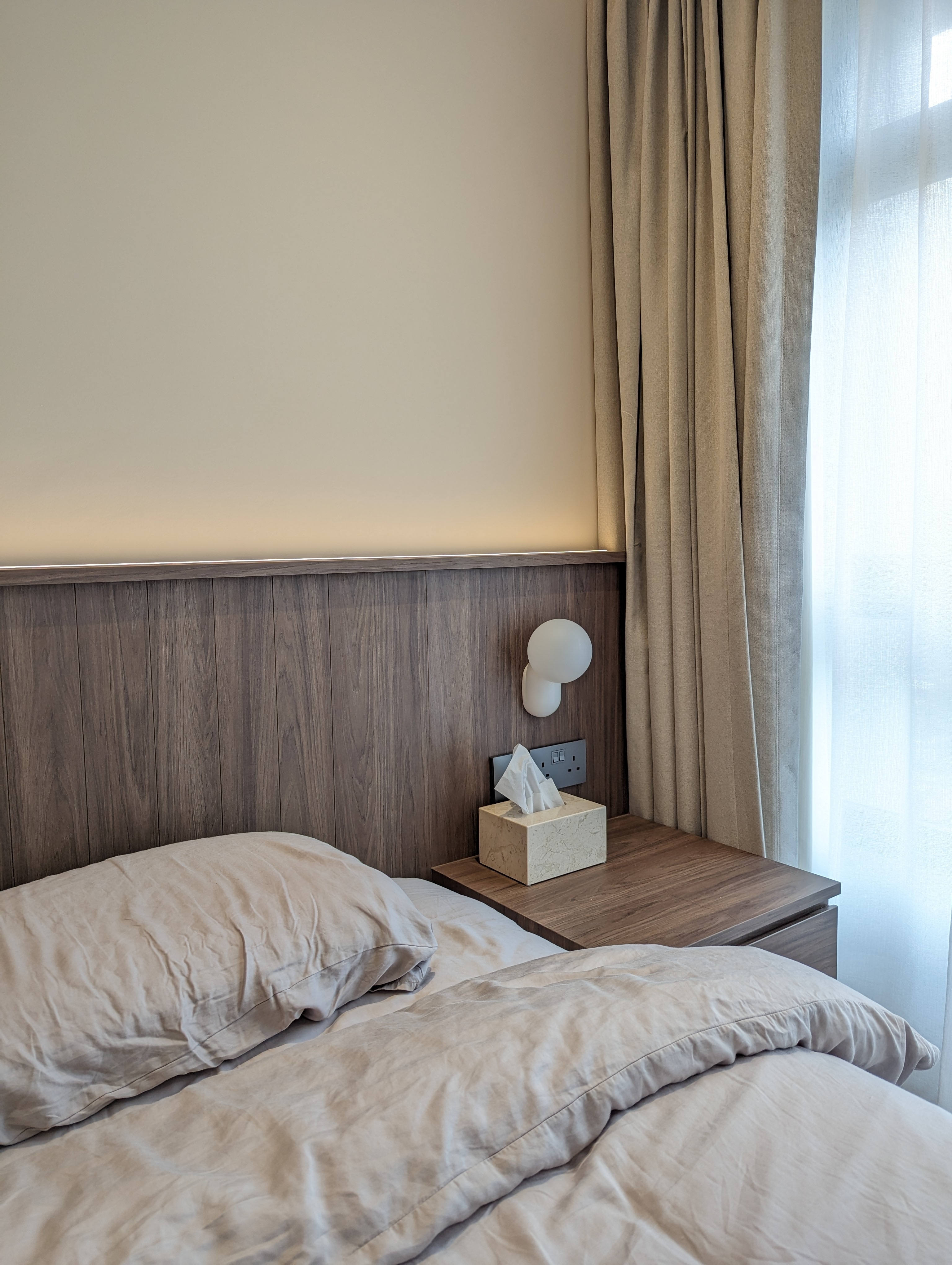 When function meets aesthetics  - Wooden headboard, beige curtains, bedside table, white lamp, tissue box, wooden paneling
