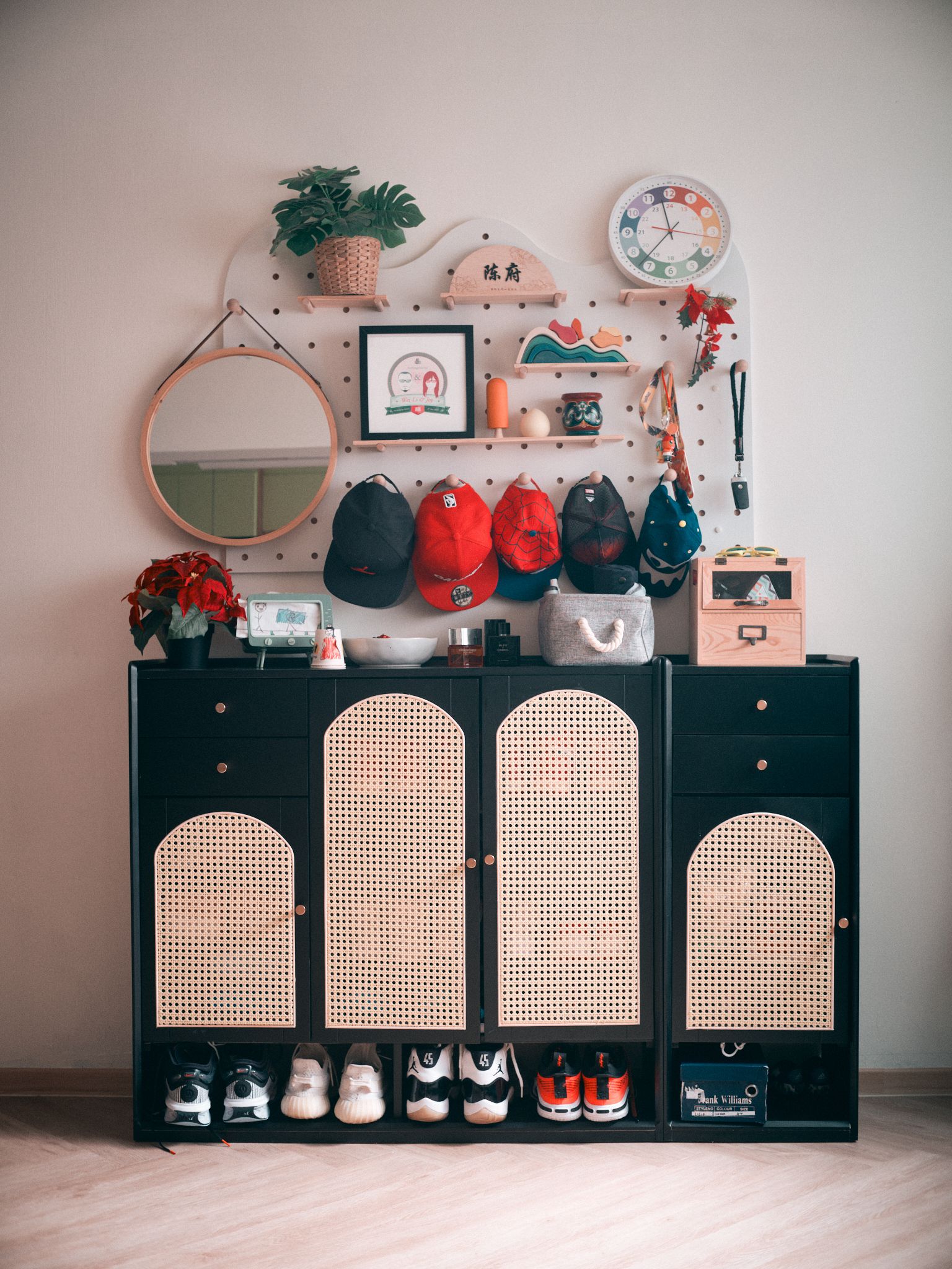 An entryway built around family habits - wall-mounted organizer, black cabinet, woven dividers, sneakers, sports shoes