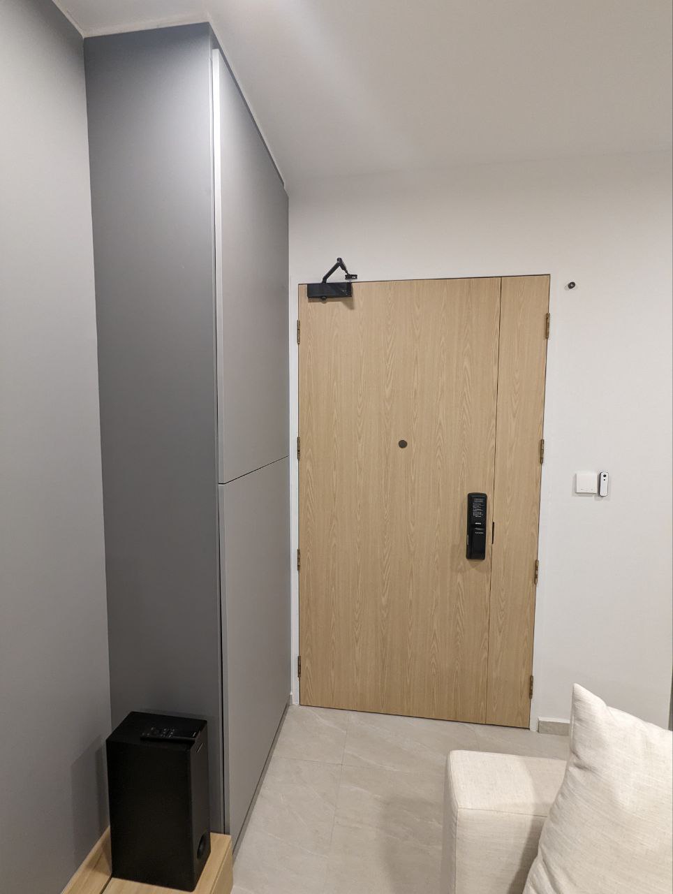 Entryway to our hearts - Wooden door, gray cabinet, black speaker, minimalist decor, modern interior, light gray walls, white