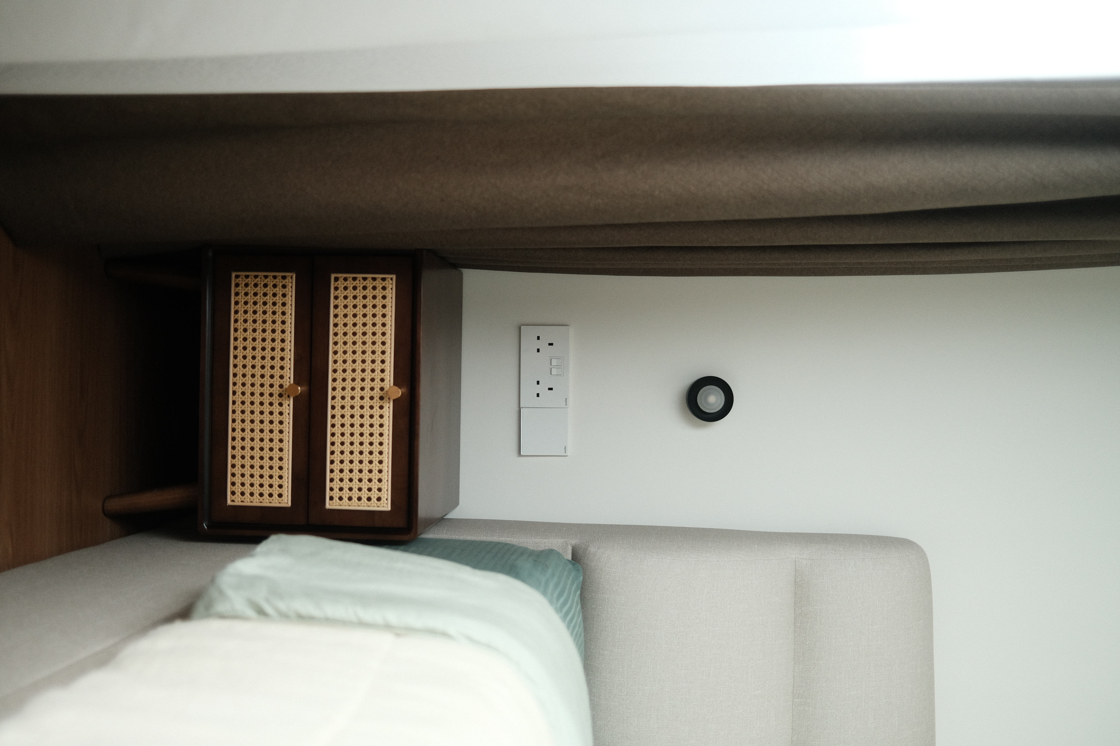 A warm and zen space (Japandi) - Wooden nightstand with intricate lattice design, beige upholstered bed frame, light green