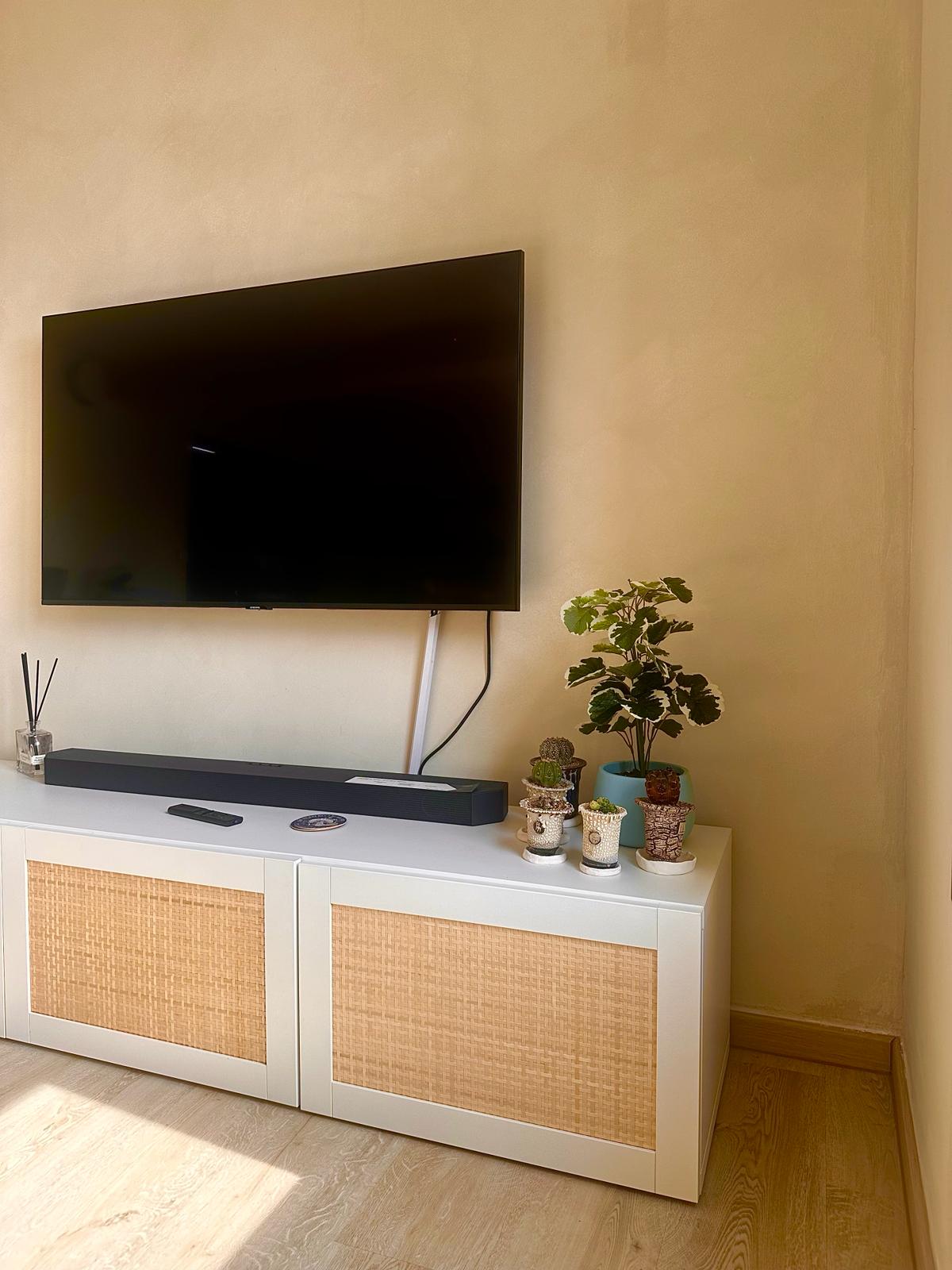 Wabi-Sabi home designed by Chefs to host Private Dinners - Large flat-screen TV mounted on beige wall, sleek white