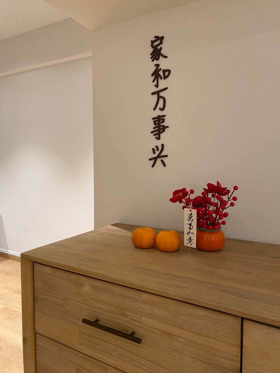 A Modern Farmhouse - Wooden dresser, minimalist design, light wood finish, two oranges, red flowers in a vase, Chinese