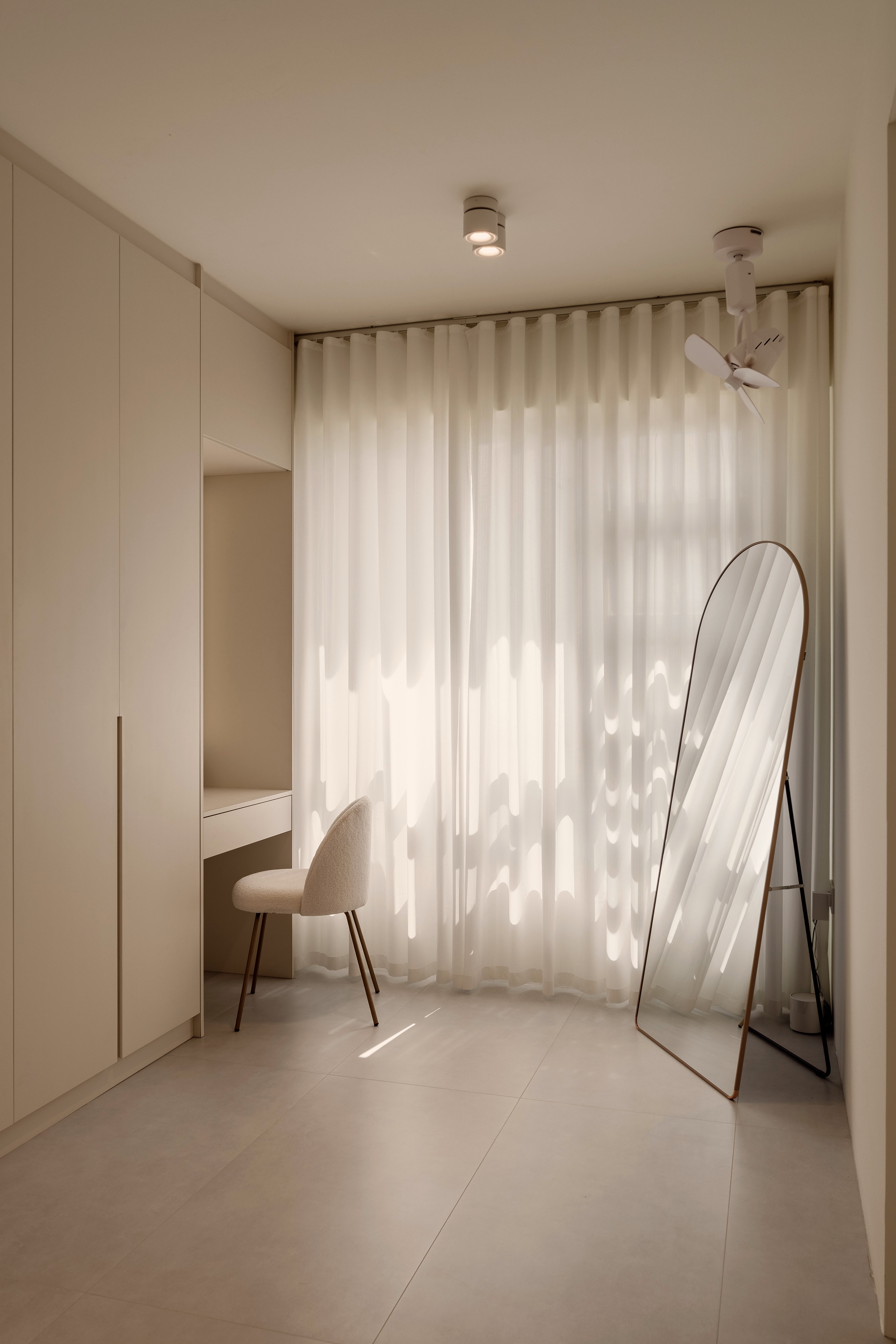 A Creamy Home With Sunrise View  - Minimalist room with beige walls and floor, soft natural light streaming through sheer