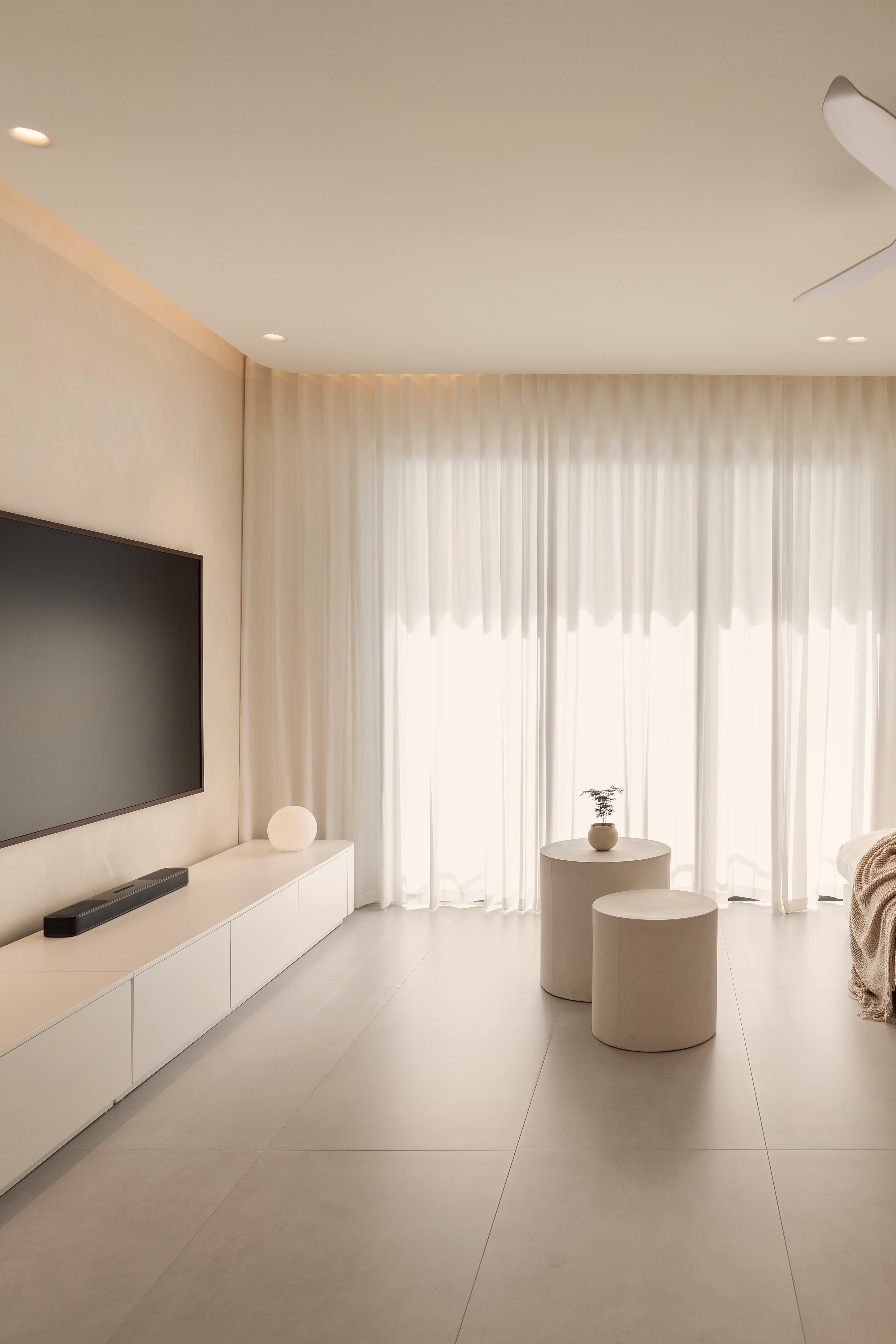 A Creamy Home With Sunrise View  - Modern minimalist living room, sleek white furniture, large flat-screen TV, soft beige
